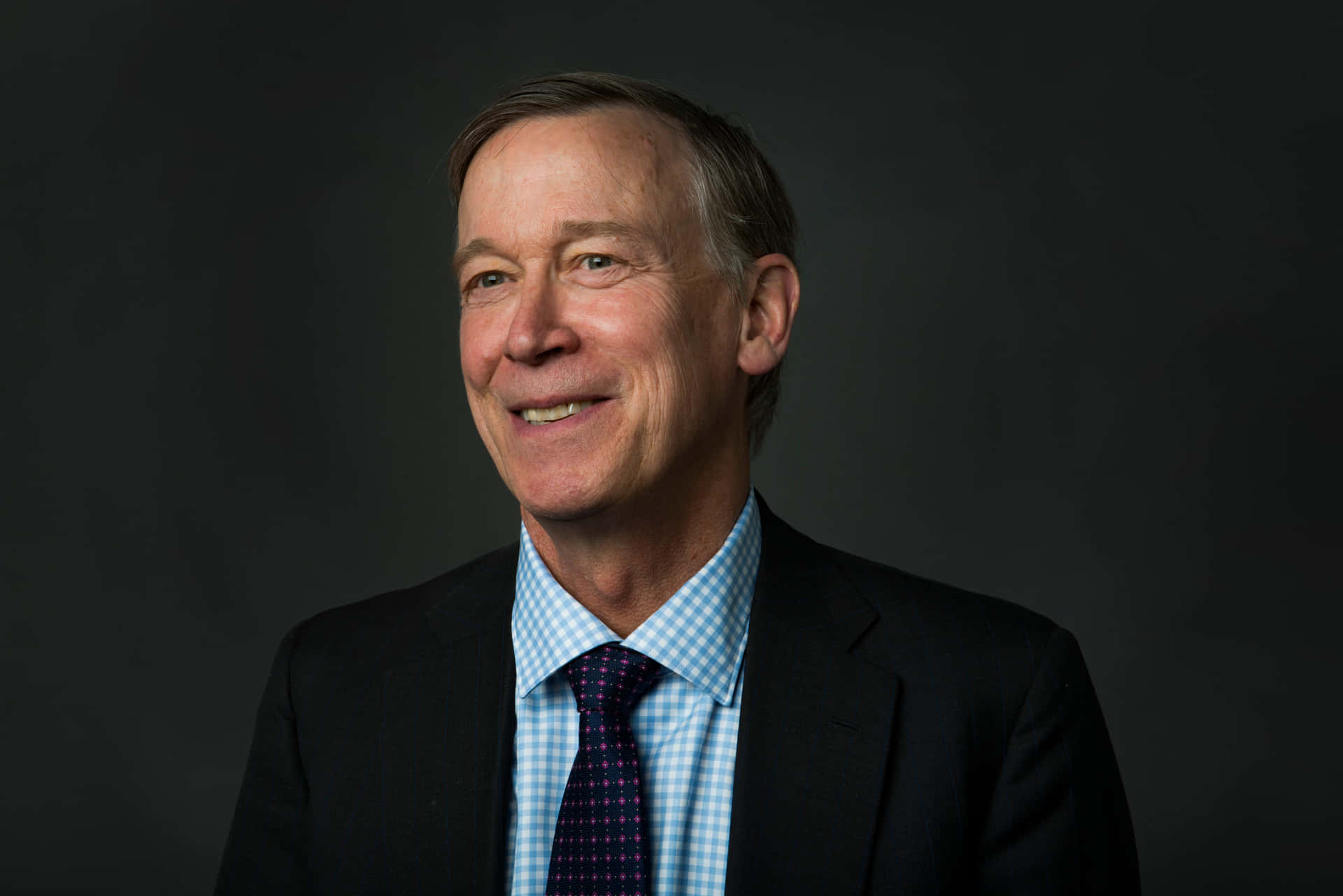 John Hickenlooper With A Dark Gray Background
