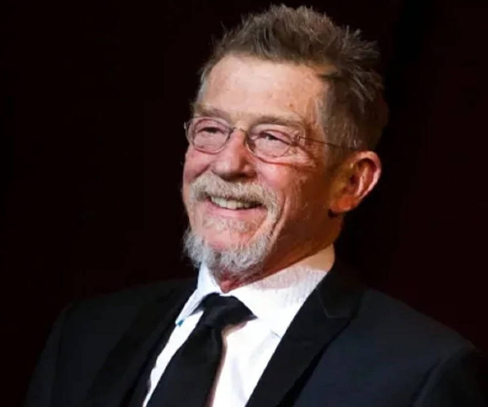 John Hurt Smiling Suit And Glasses Background