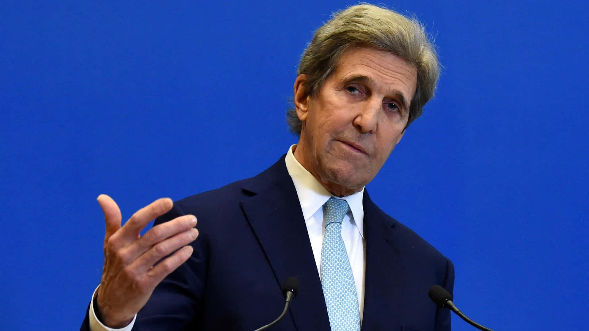 John Kerry Speaking At A Press Conference Background
