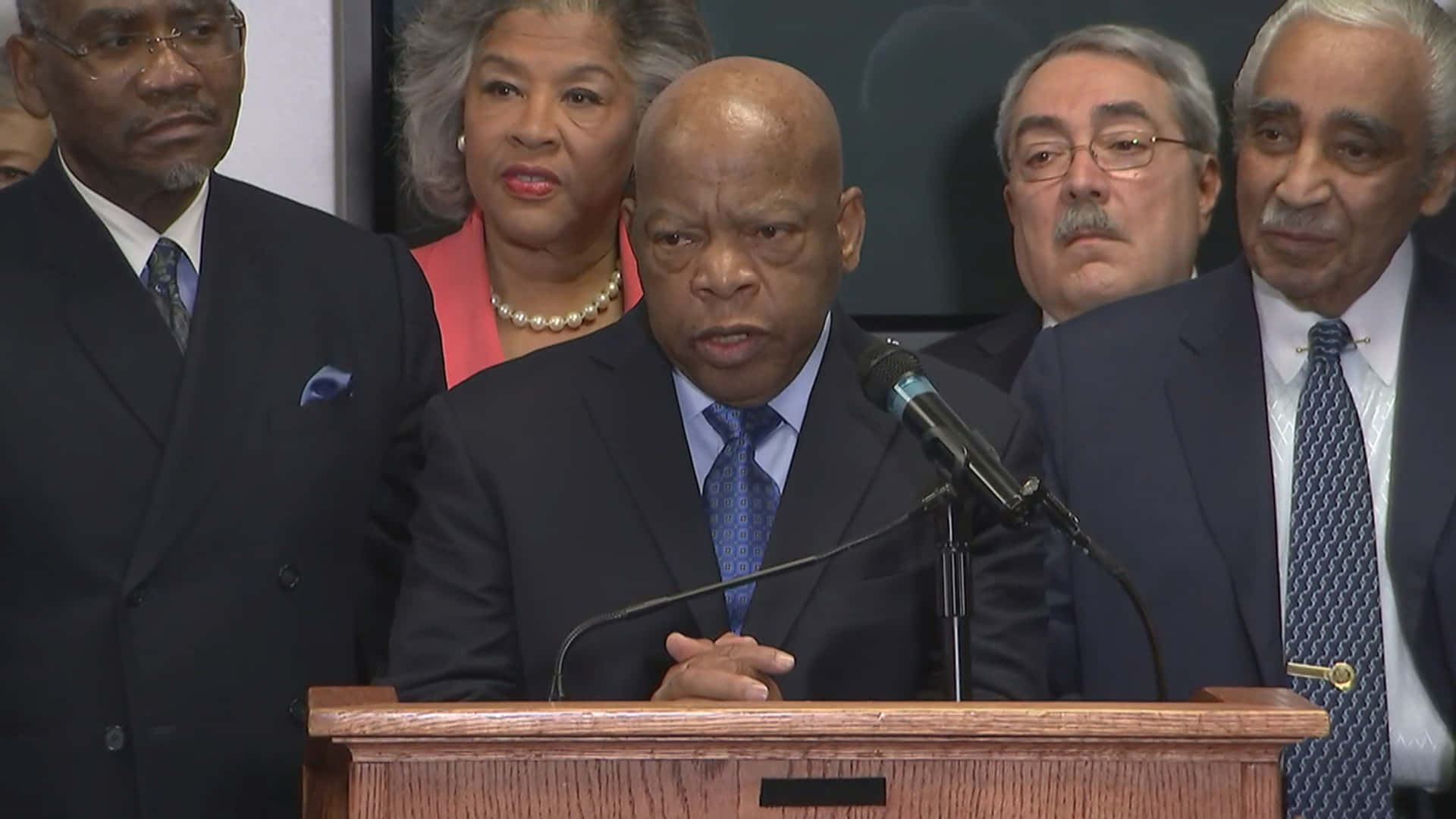 John Lewis Speaking On A Podium Background
