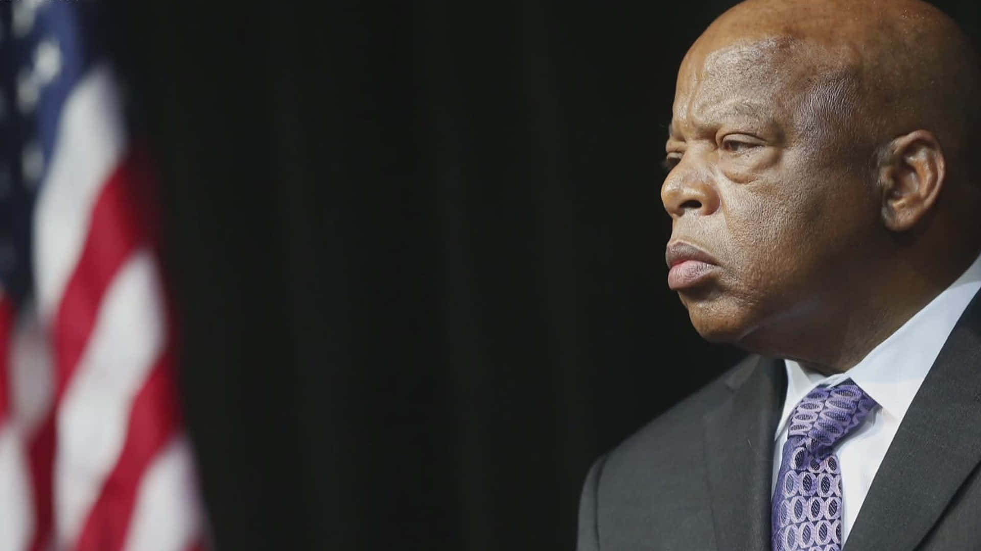John Lewis With An American Flag Background