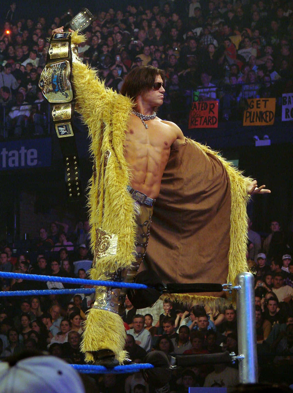 John Morrison Displaying His Wwe Championship Belt, Clad In A Flashy Yellow Coat. Background