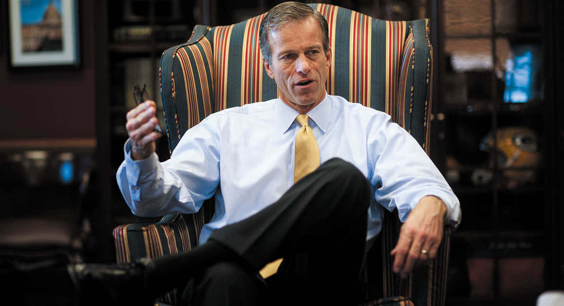 John Thune On A Striped Chair Background
