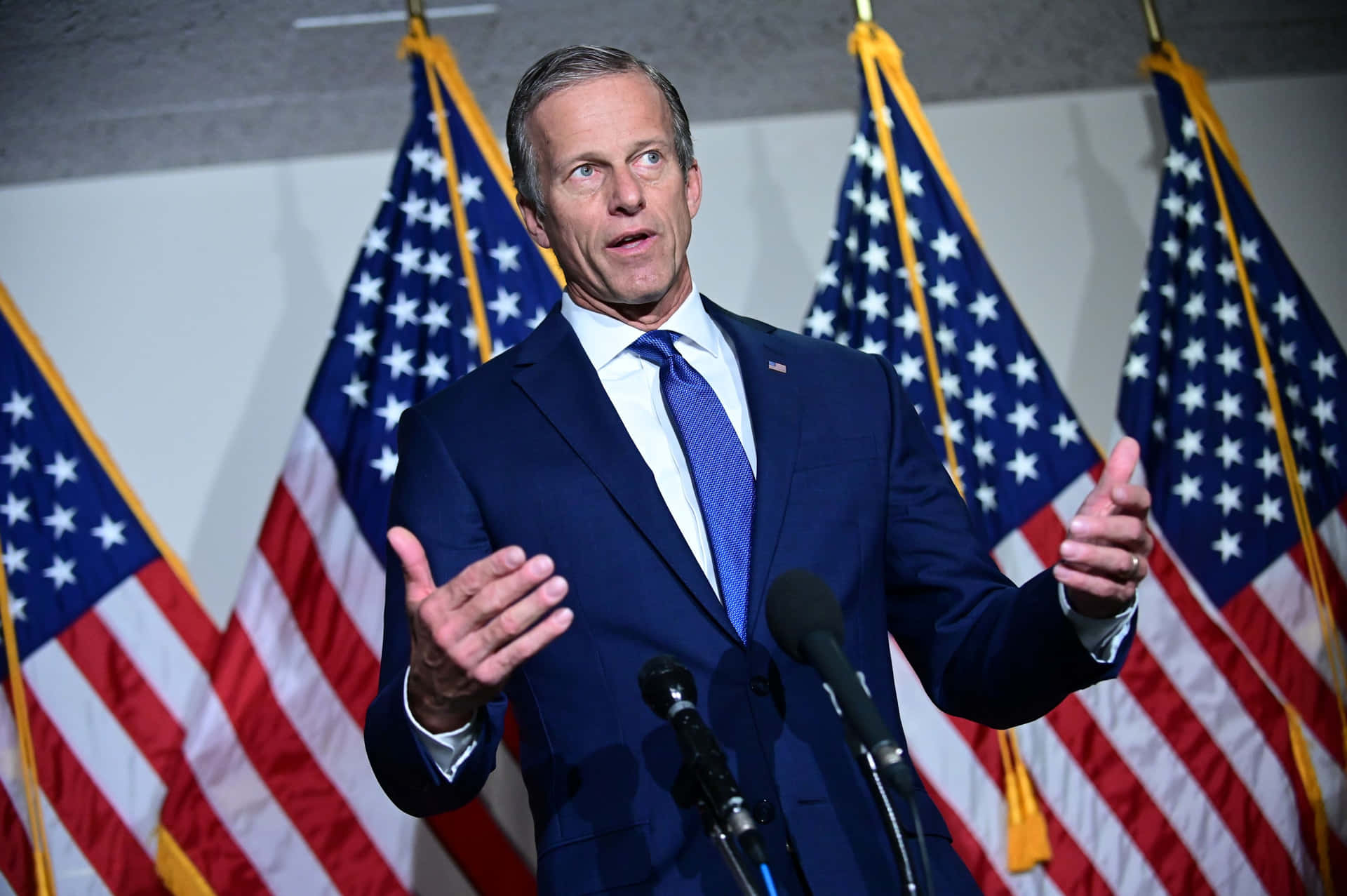 John Thune With Four Us Flags Background