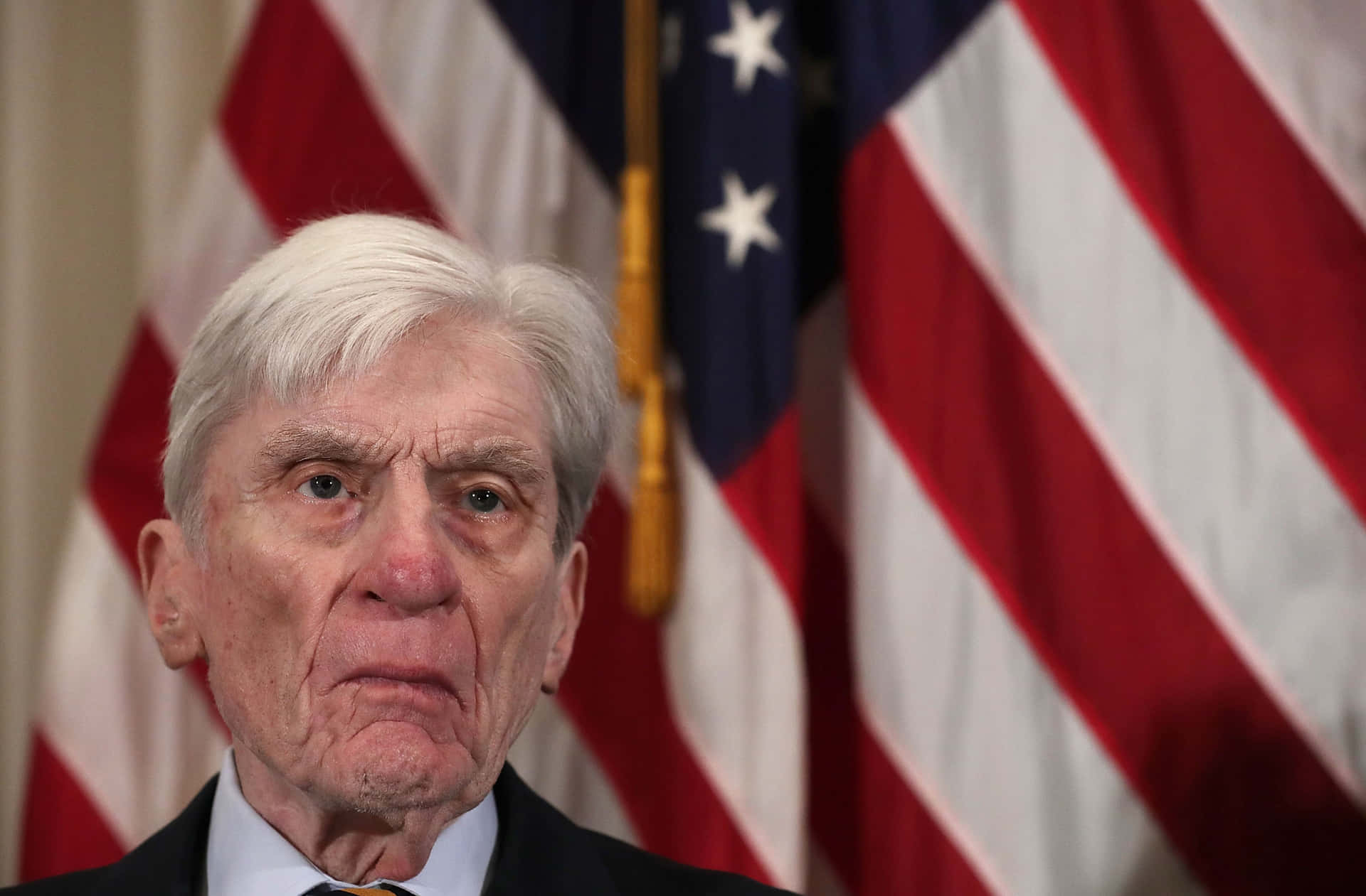 John Warner In Front Of Us Flag Background