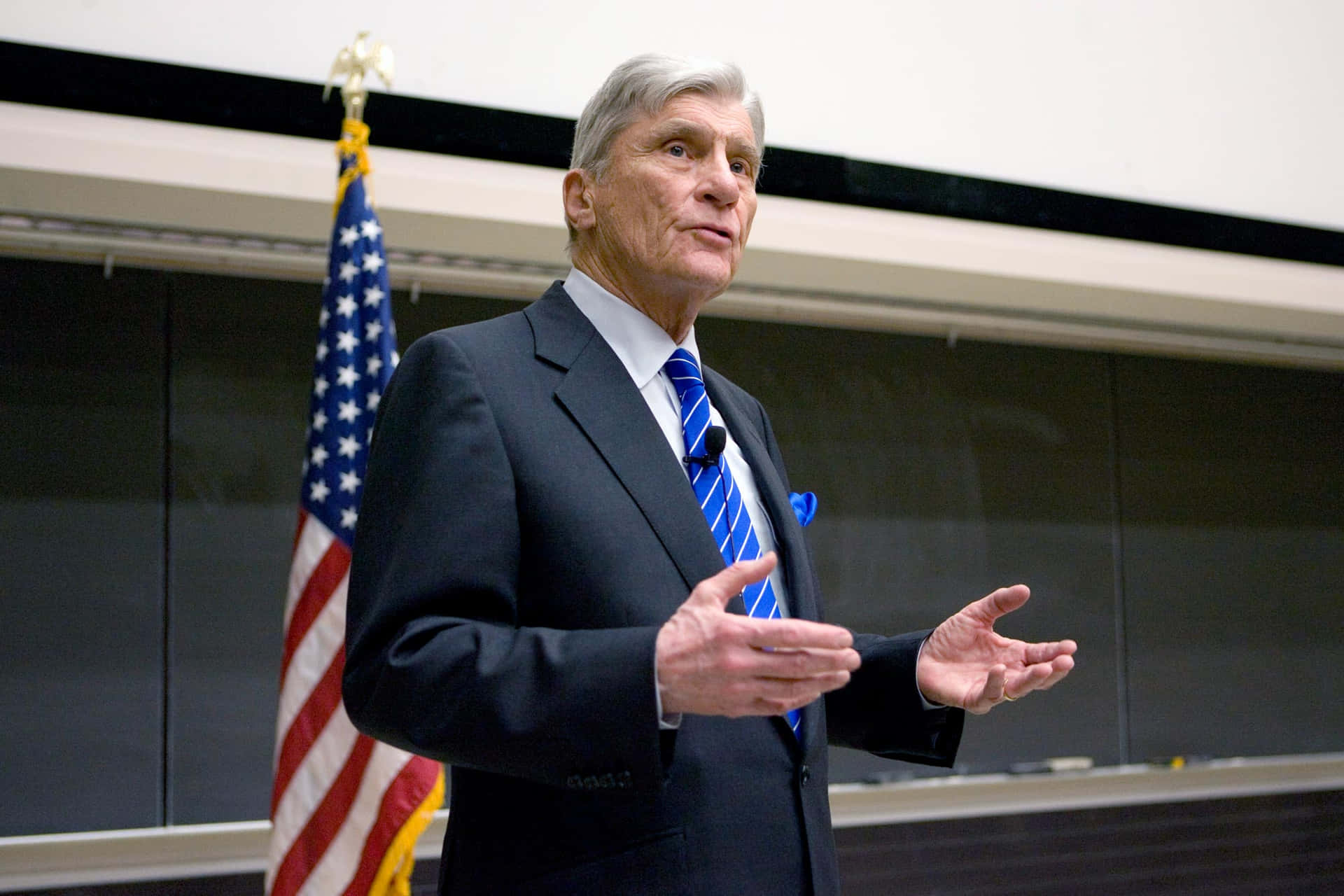 John Warner Speaking In Front Of American Flag
