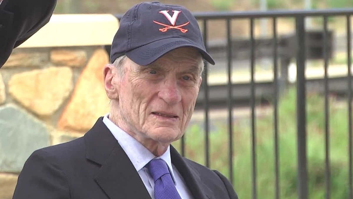 John Warner Wearing Suit With A Cap Background