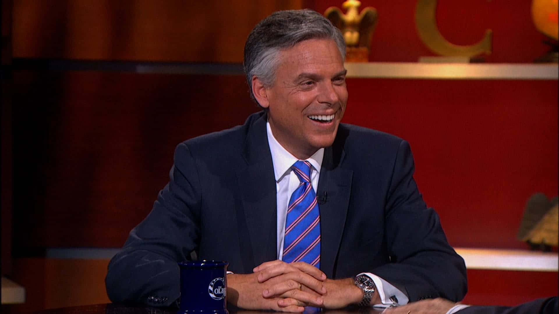 Jon Huntsman With Entwined Fingers In Thought Background