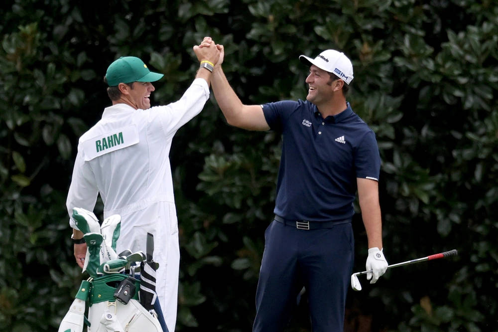 Jon Rahm Handshaking A Caddie Background