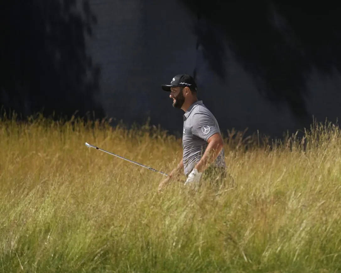 Jon Rahm In The Grasses Background