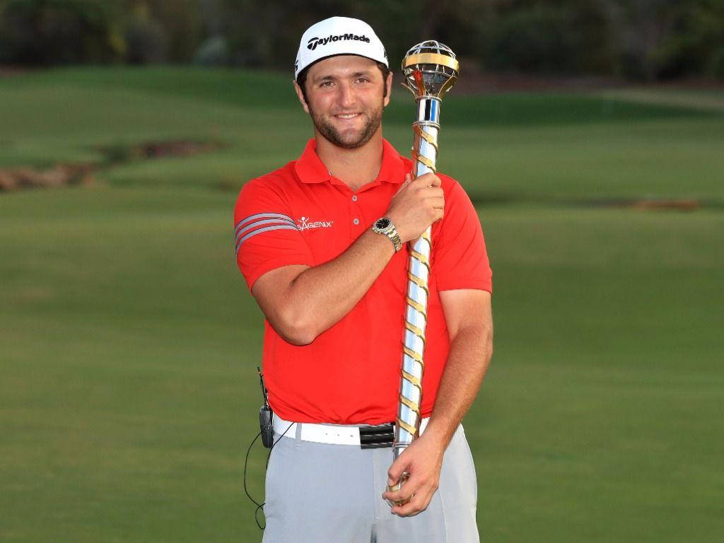 Jon Rahm With A Gold Baton Background