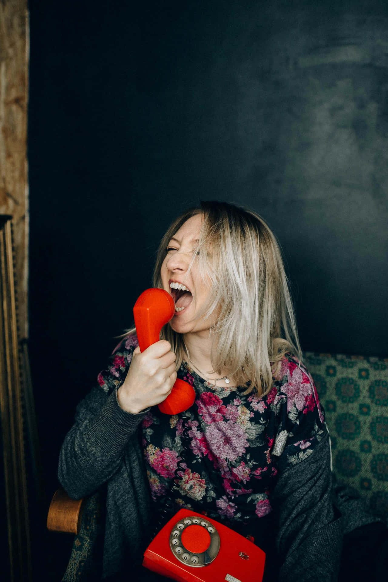 Joyful Woman Yelling Into Red Phone Background