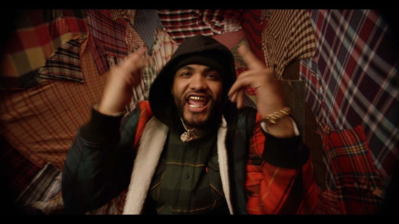 Joyner Lucas Embodies Suave Hip-hop Style In This Iconic Portrait Background