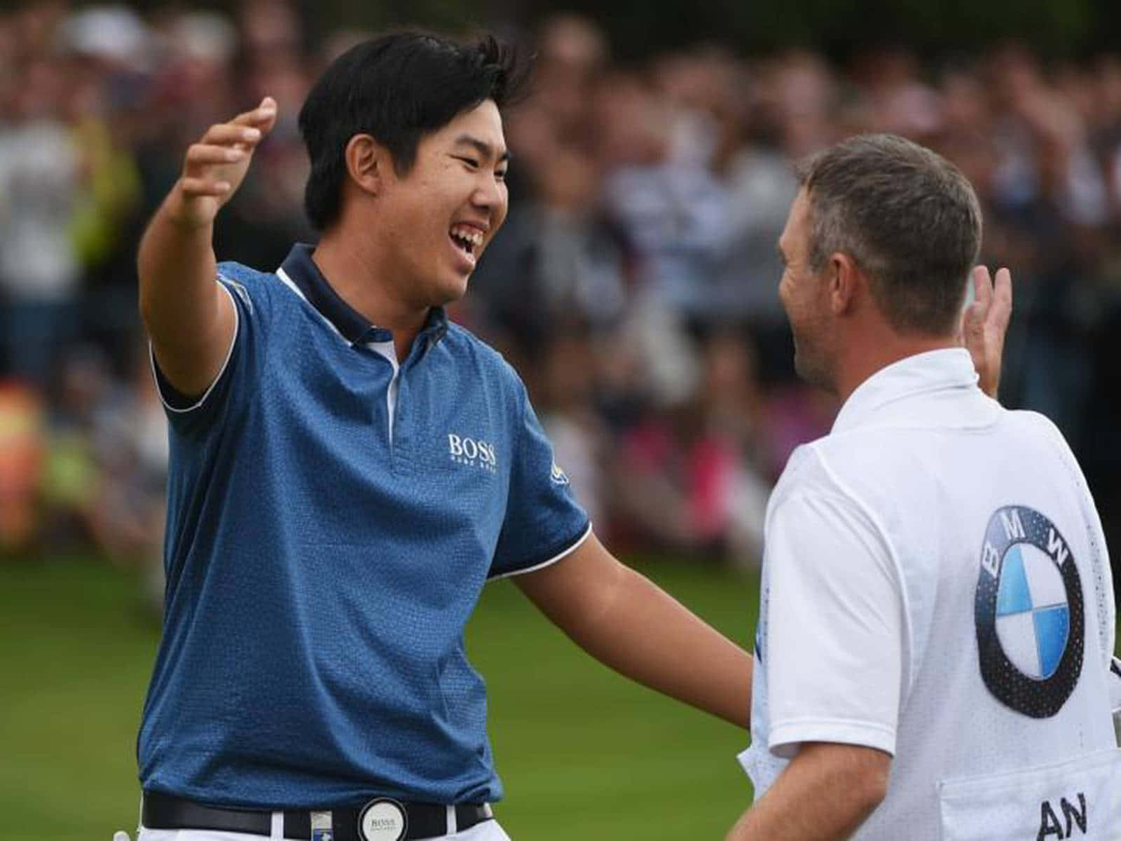 Jubilation On The Greens: Byeong Hun An And His Caddie Rejoice After Victory Background