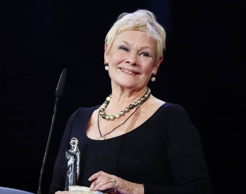 Judy Dench With A Trophy Background