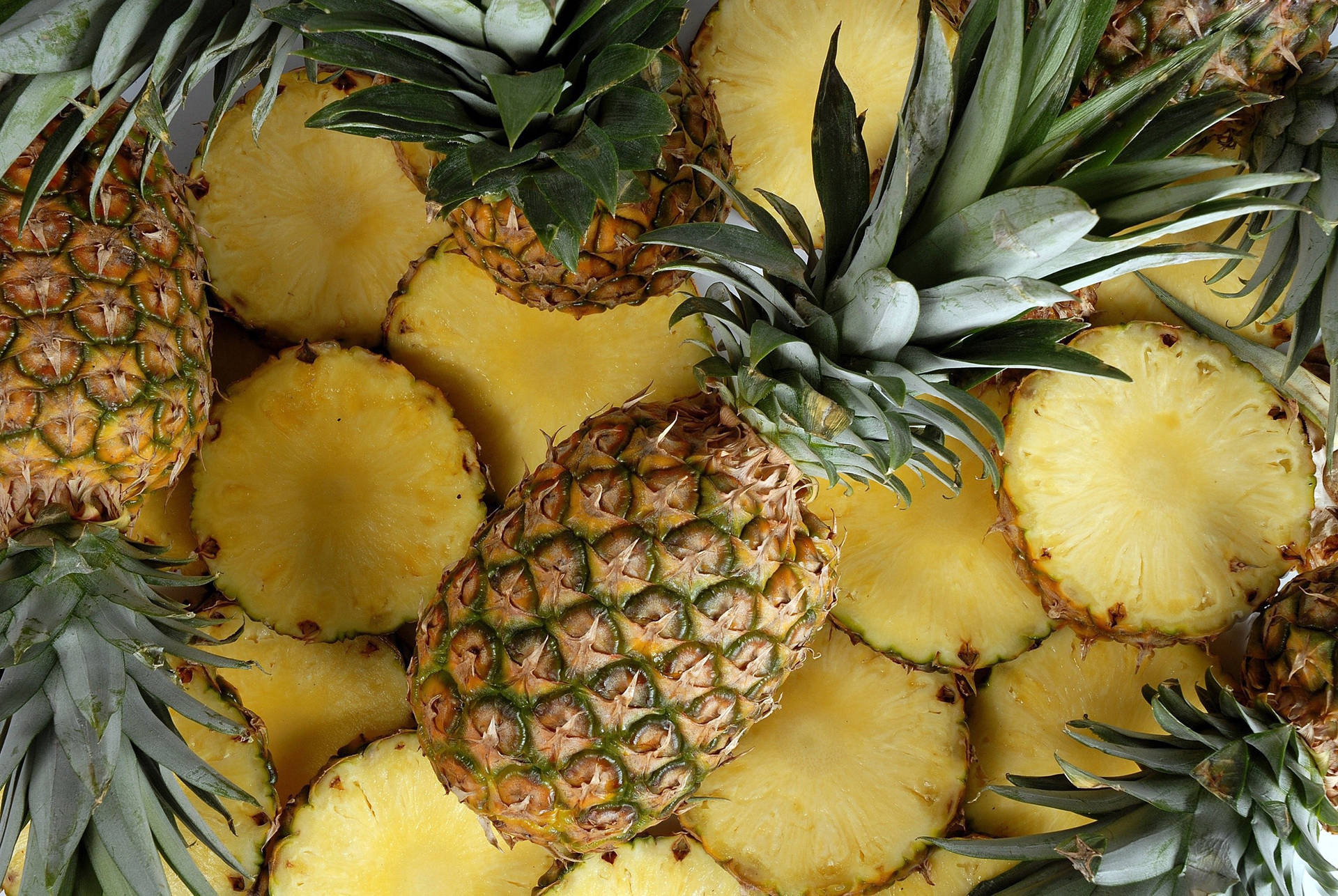 Juicy Sliced And Whole Pineapples Background