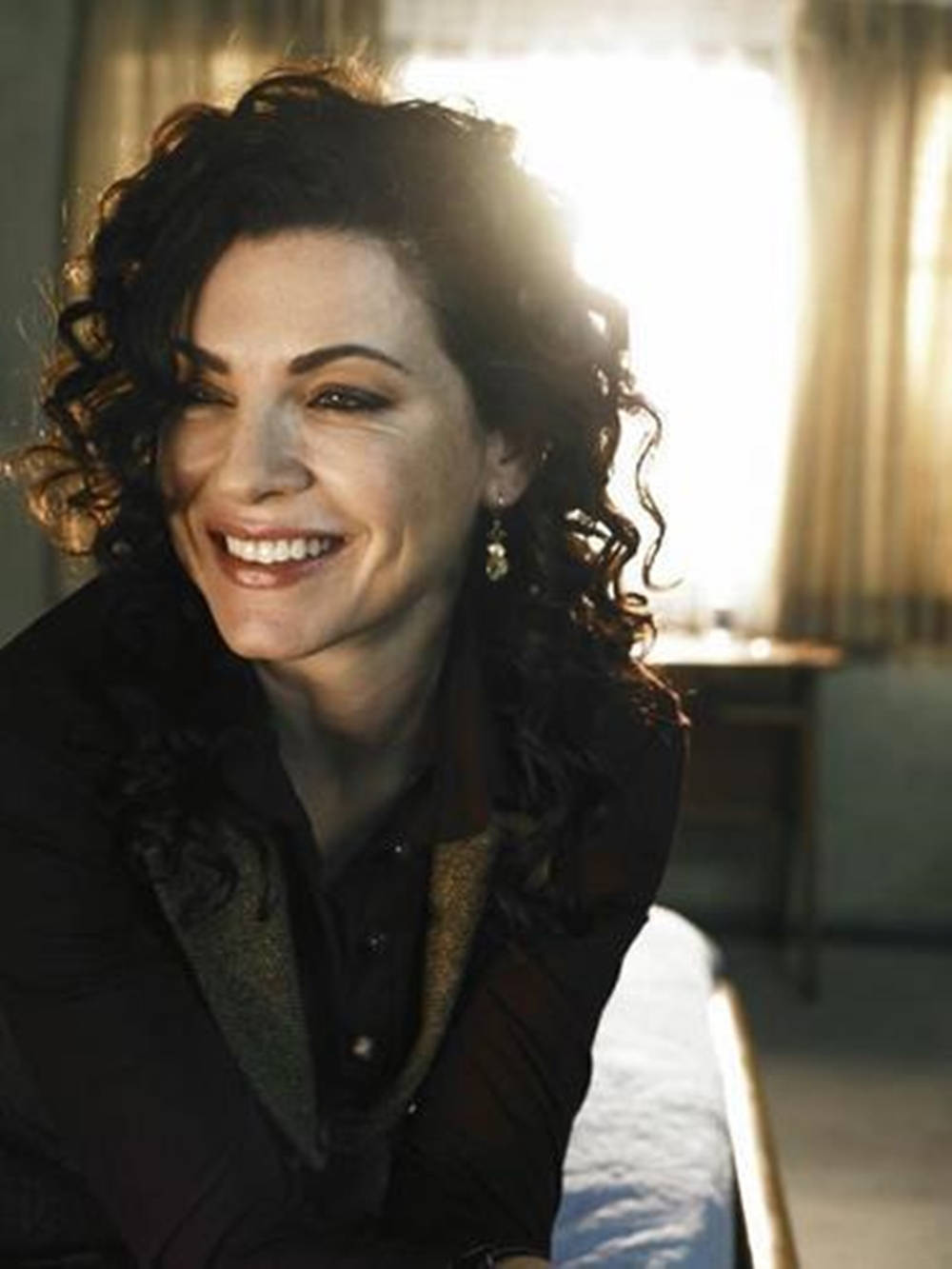 Julianna Margulies Grinning In Her Black Curls Background