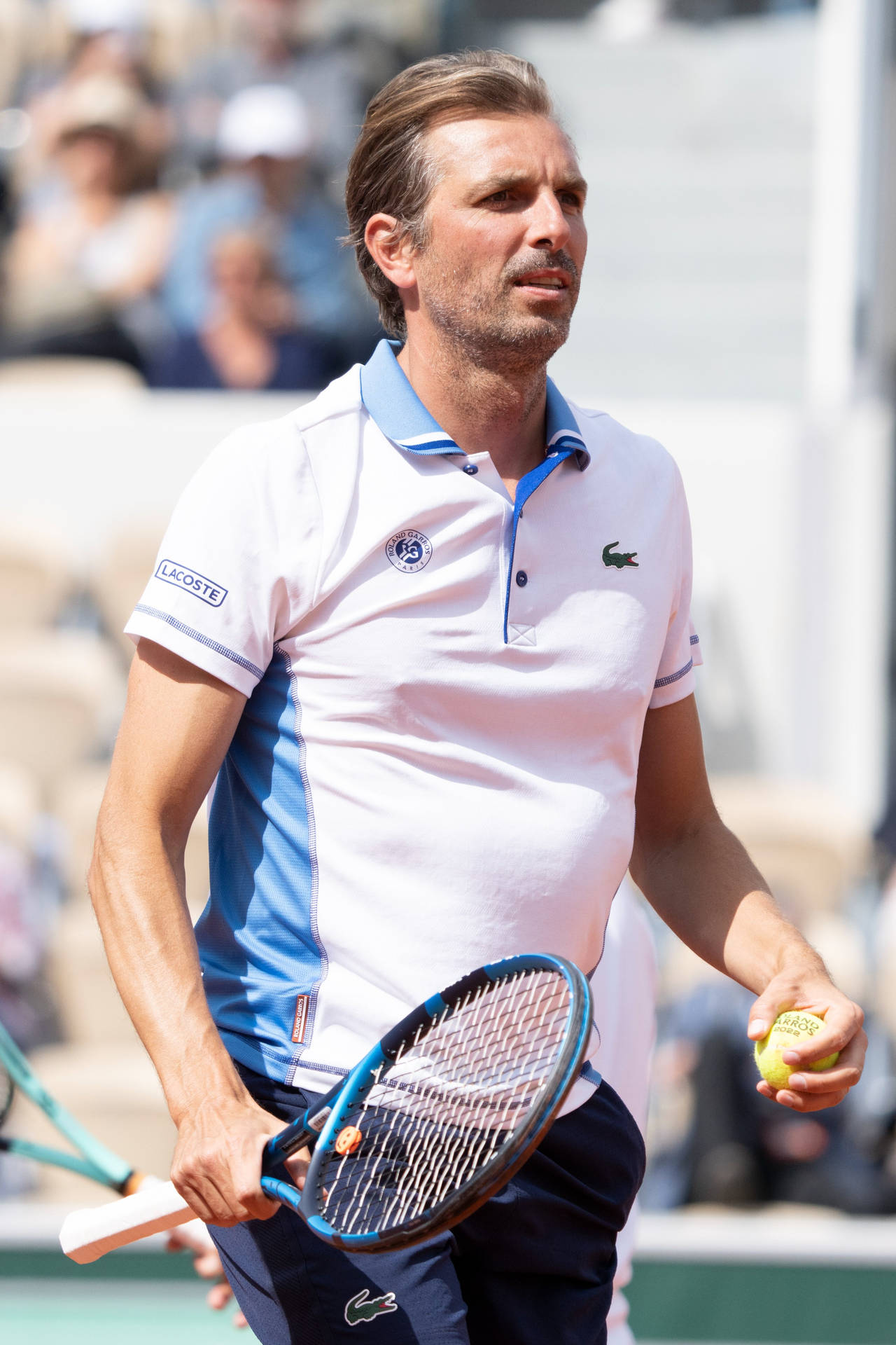 Julien Benneteau In Action- View Of French Tennis Player, Julien Benneteau, Serving During A Match, Wearing A White Polo Shirt. Background