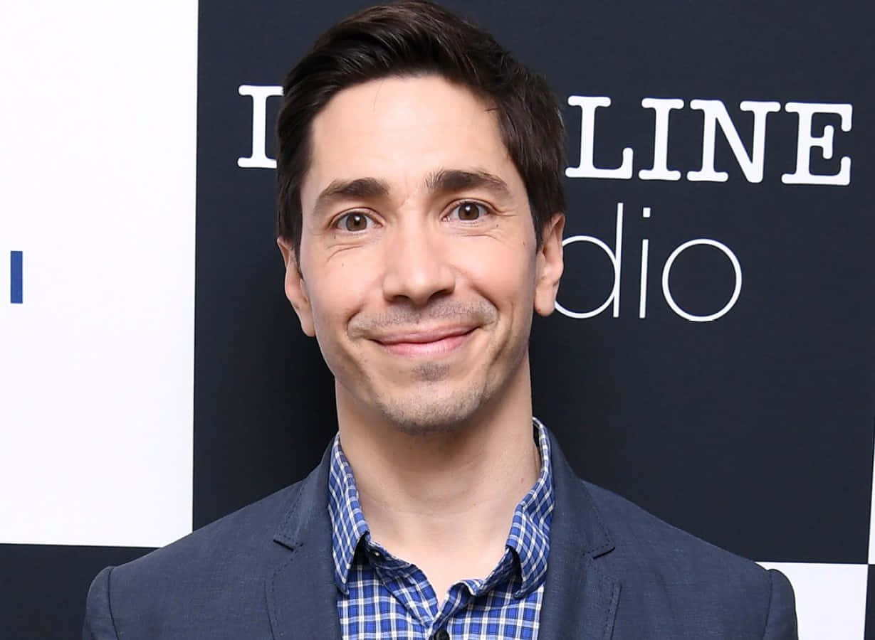 Justin Long In A Relaxed Pose Background