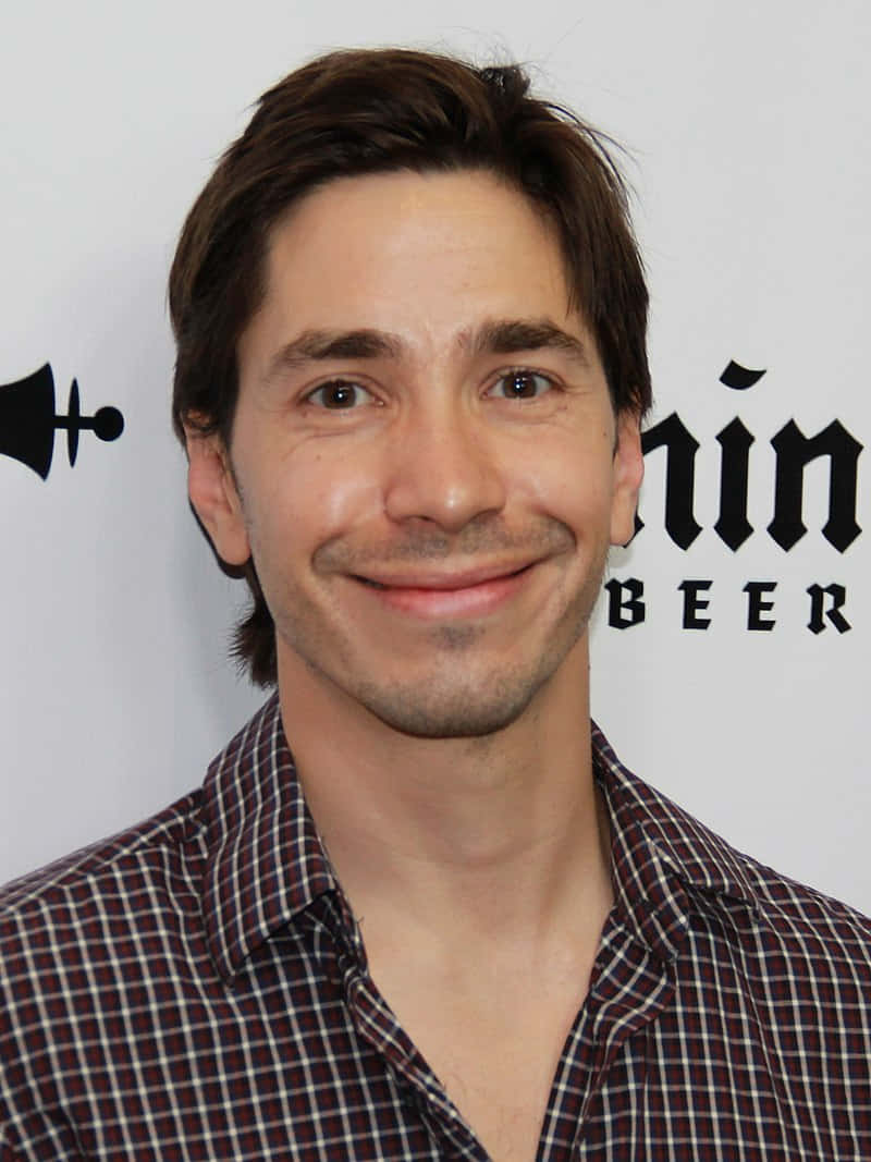 Justin Long Posing For A Candid Portrait Background
