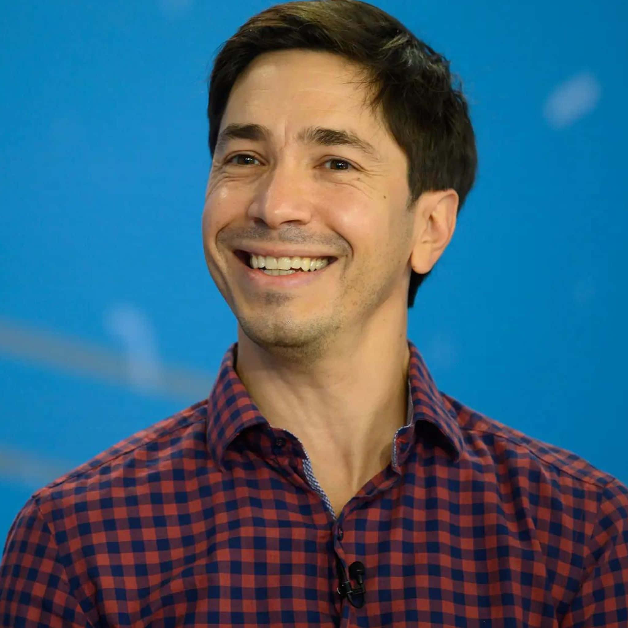 Justin Long Smiling At A Photo Shoot Background