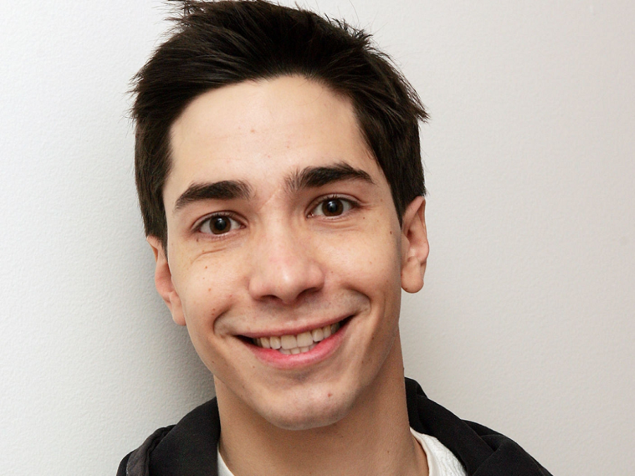 Justin Long Smiling On A Dark Background