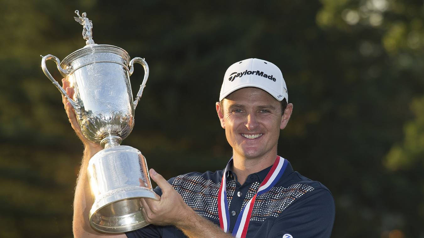 Justin Rose Smiling While Raising A Trophy Background