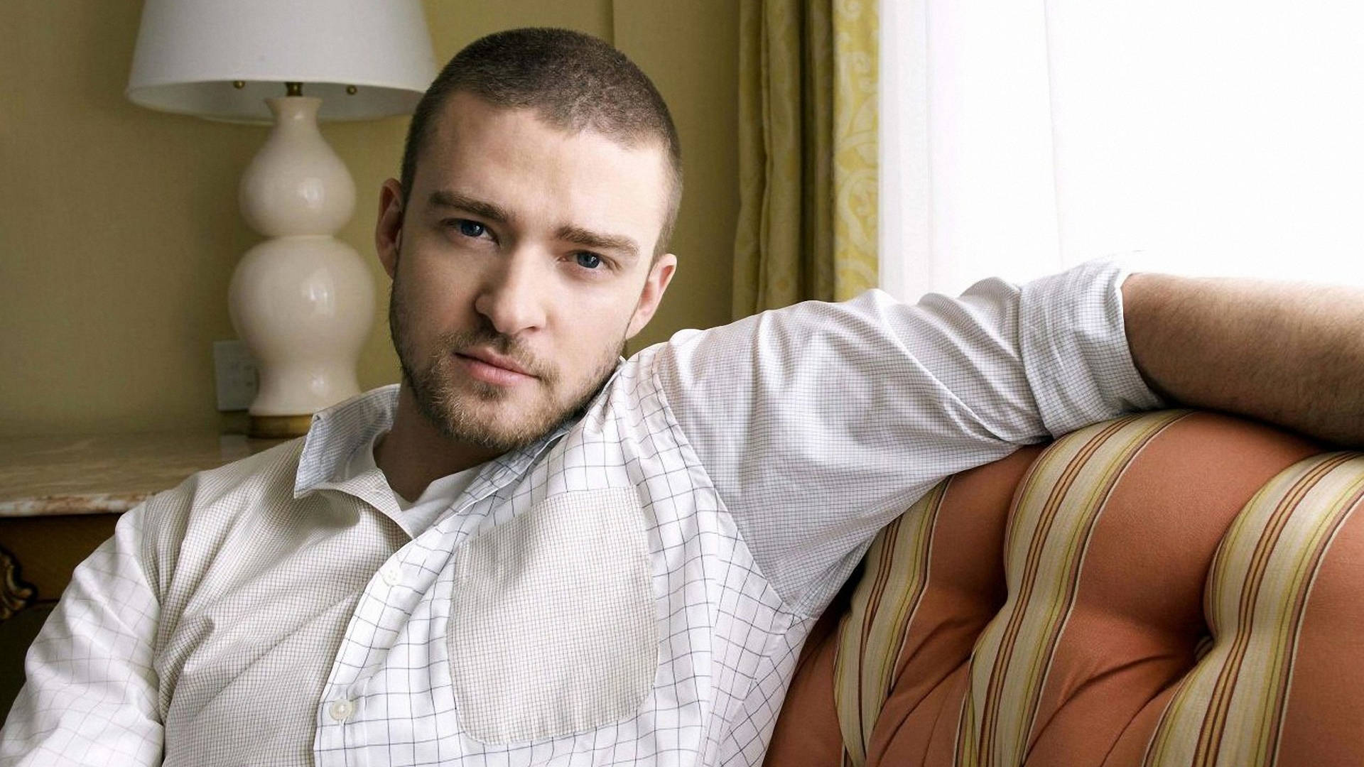 Justin Timberlake Posing On Sofa Background