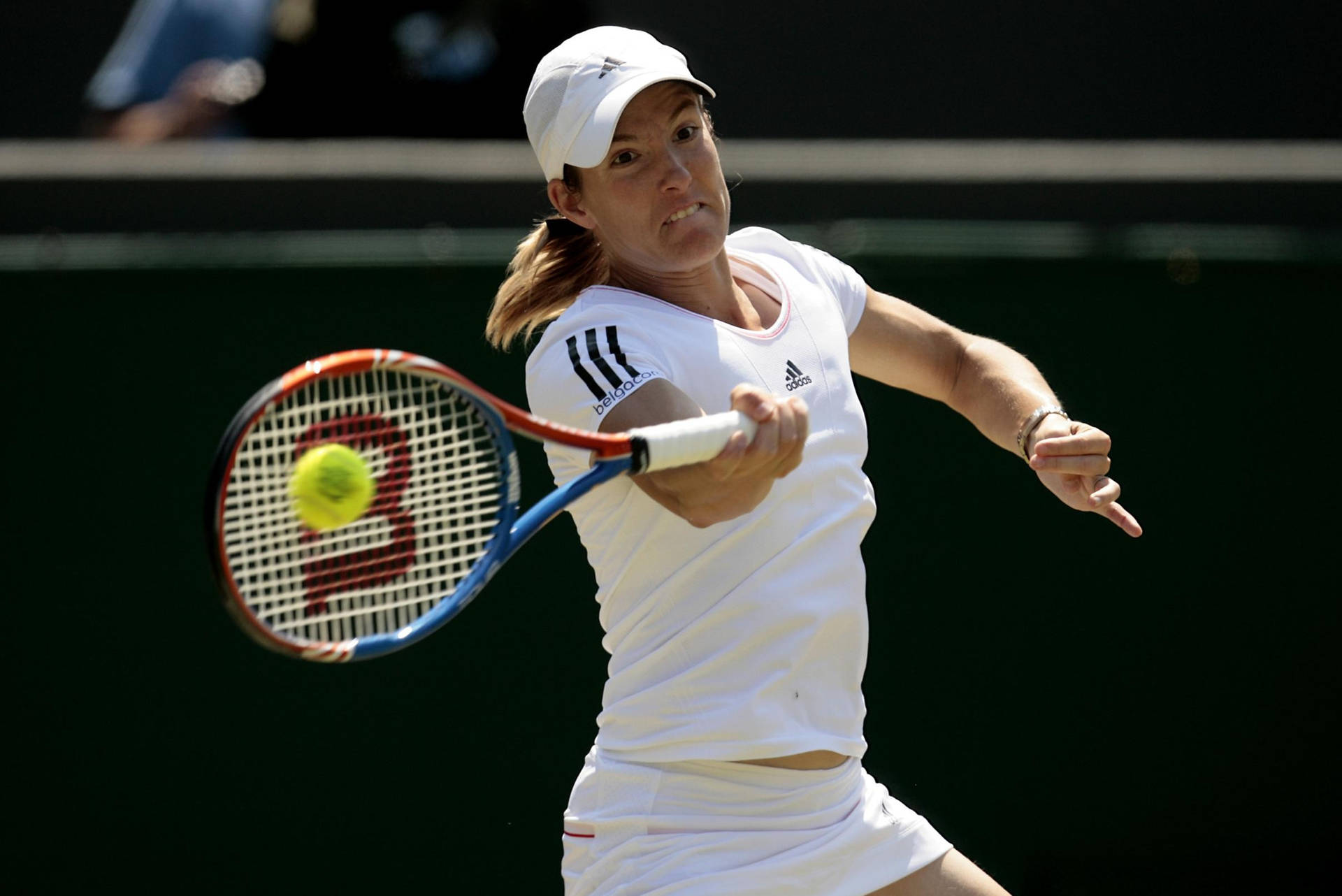 Justine Henin Displaying Her Powerful Backhand During A Match Background