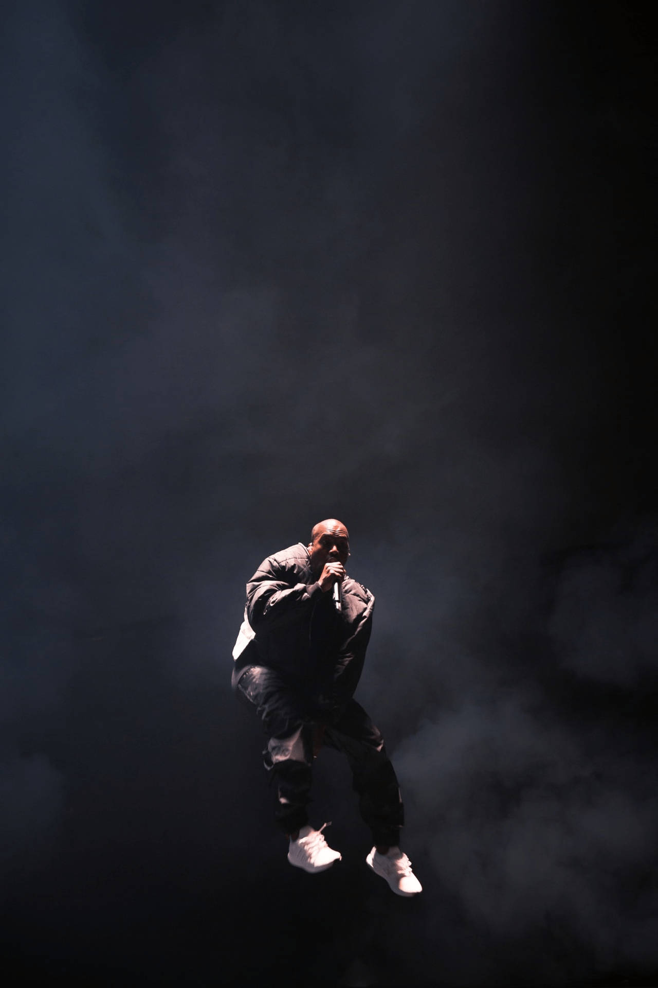 Kanye West Jumping On Stage Background