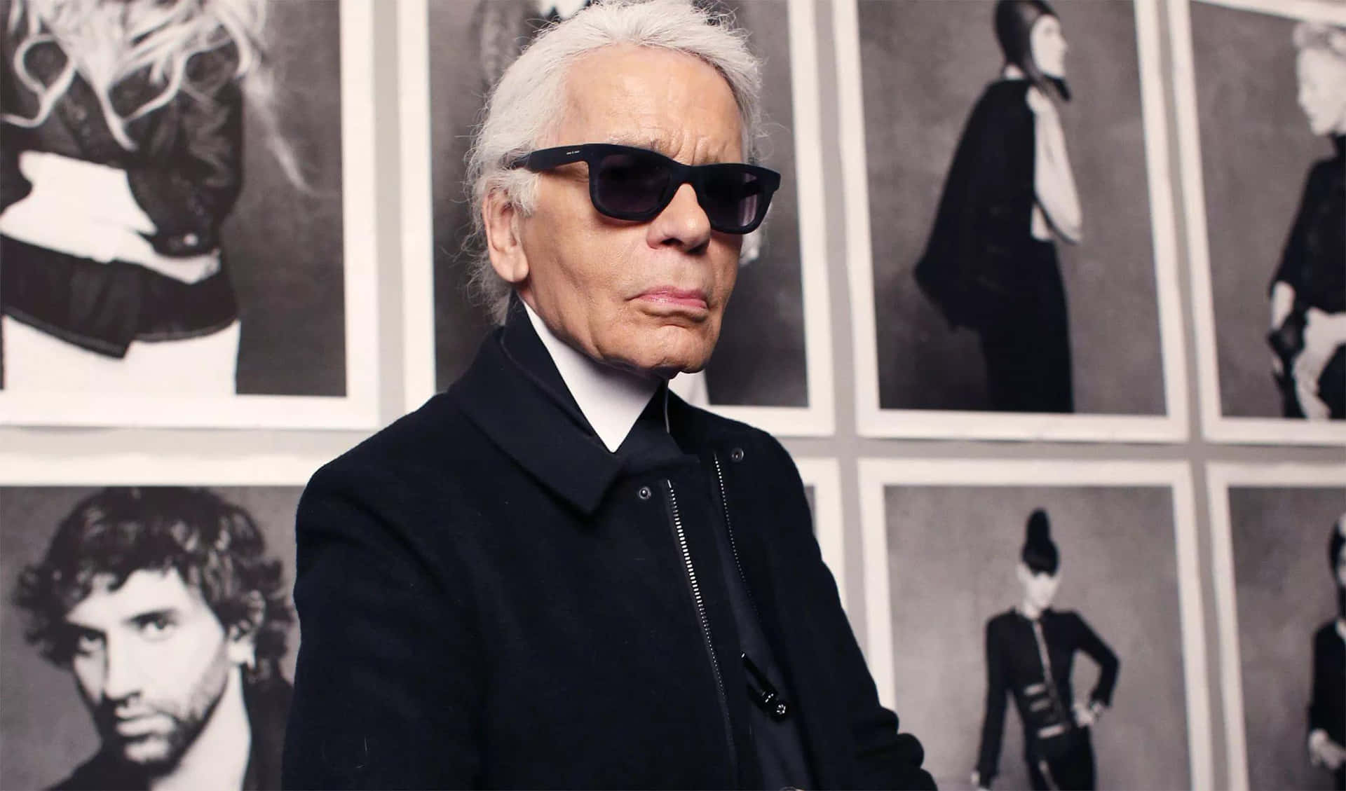 Karl Lagerfeld - A Man In Sunglasses Standing In Front Of A Wall Of Photos Background