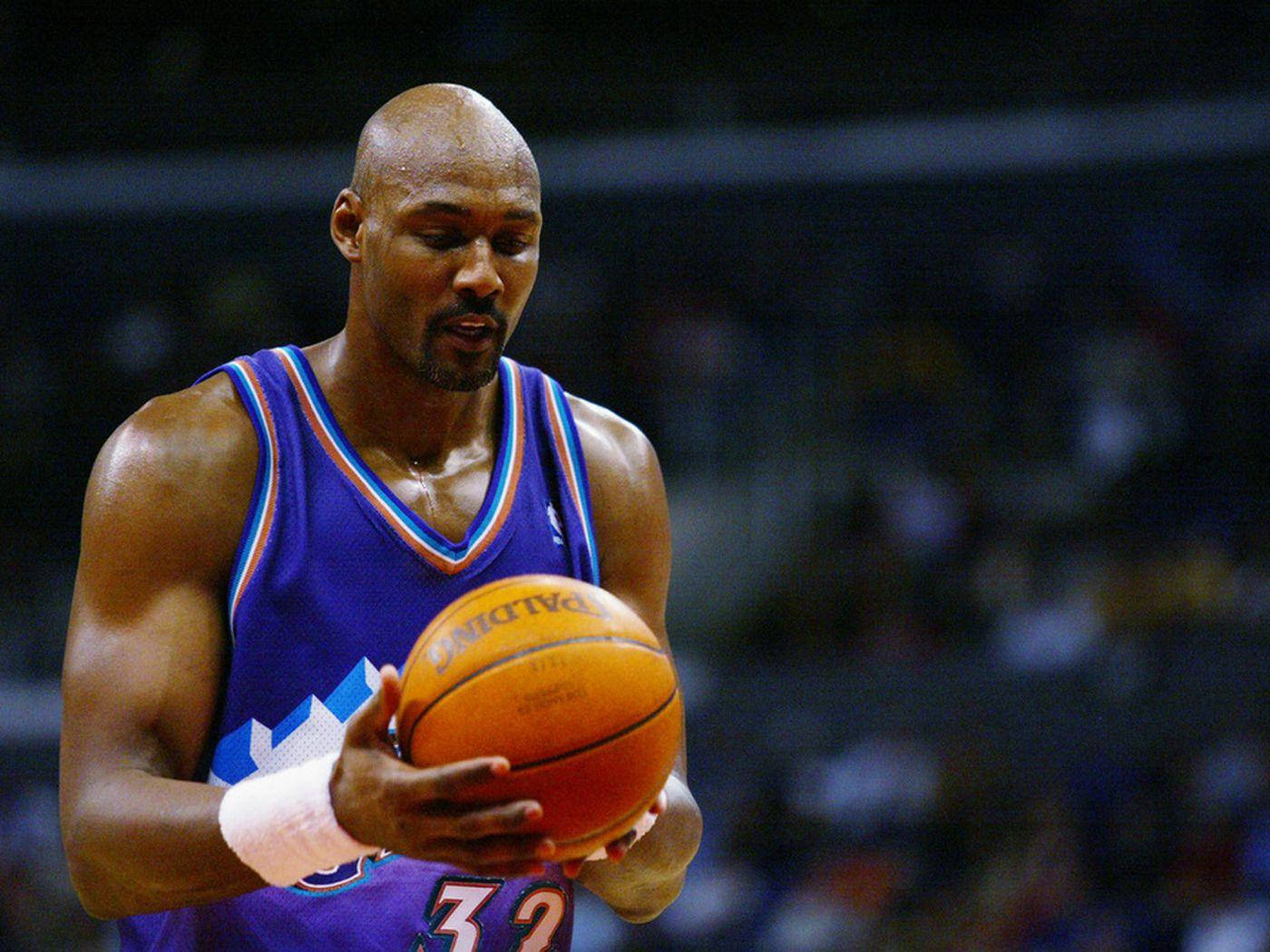 Karl Malone A Former American Basketball Player Holding A Ball Background