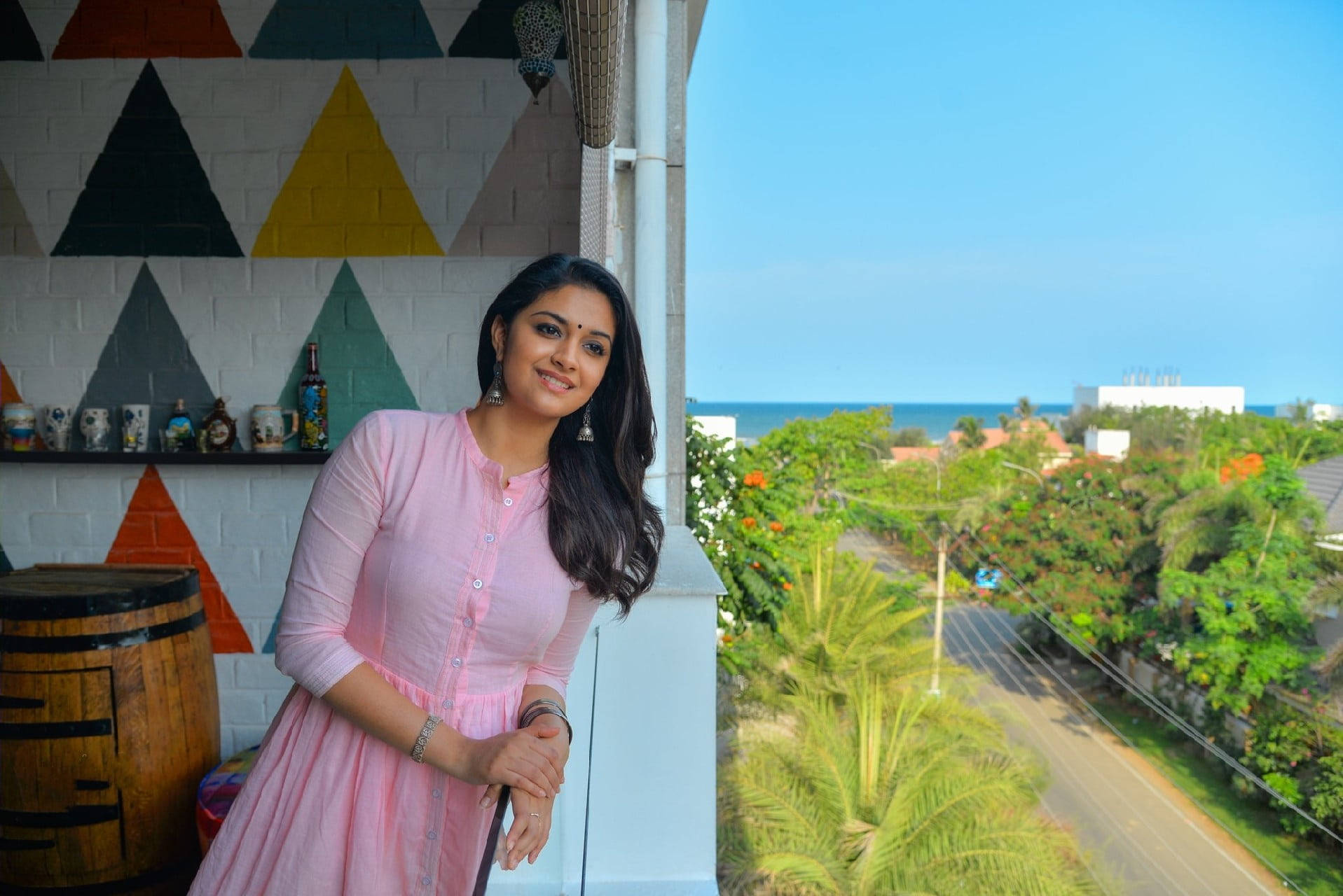 Keerthi Suresh Leaning Out A Window Background