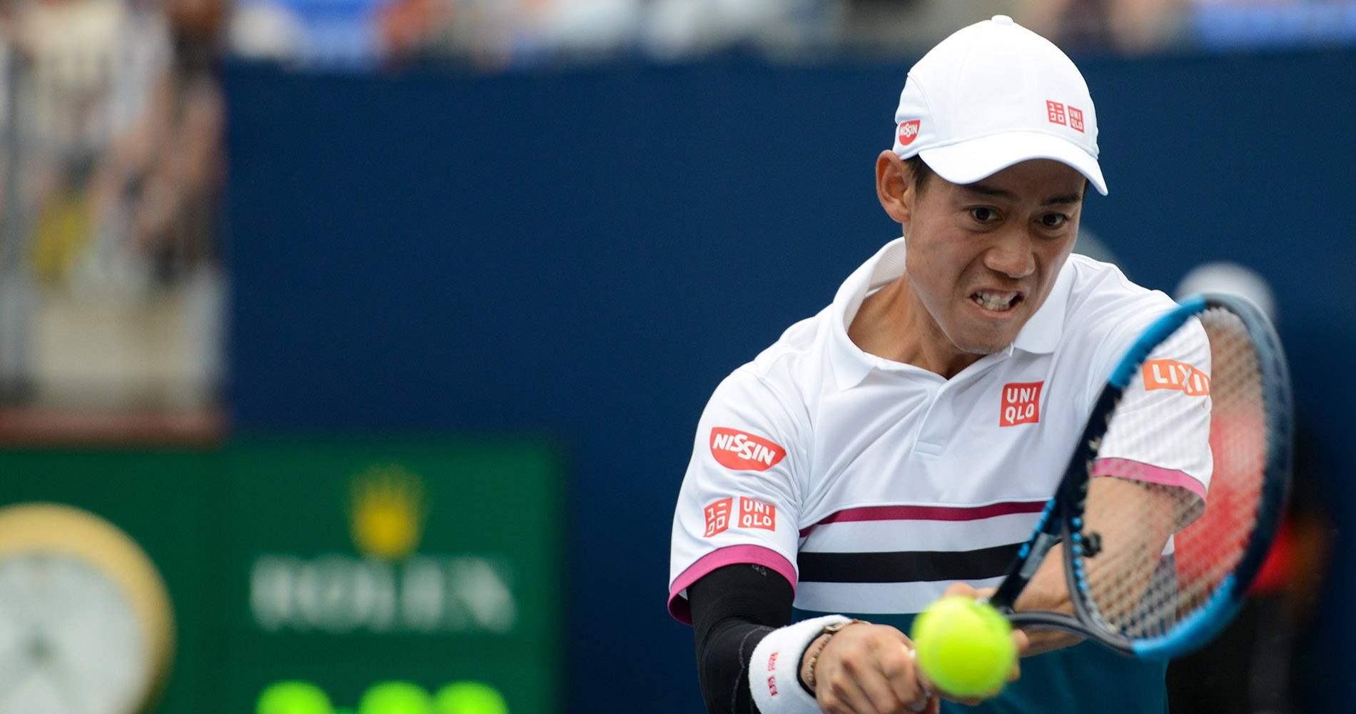 Kei Nishikori Executes A Power-packed Two-handed Stroke During A Grand Slam Background