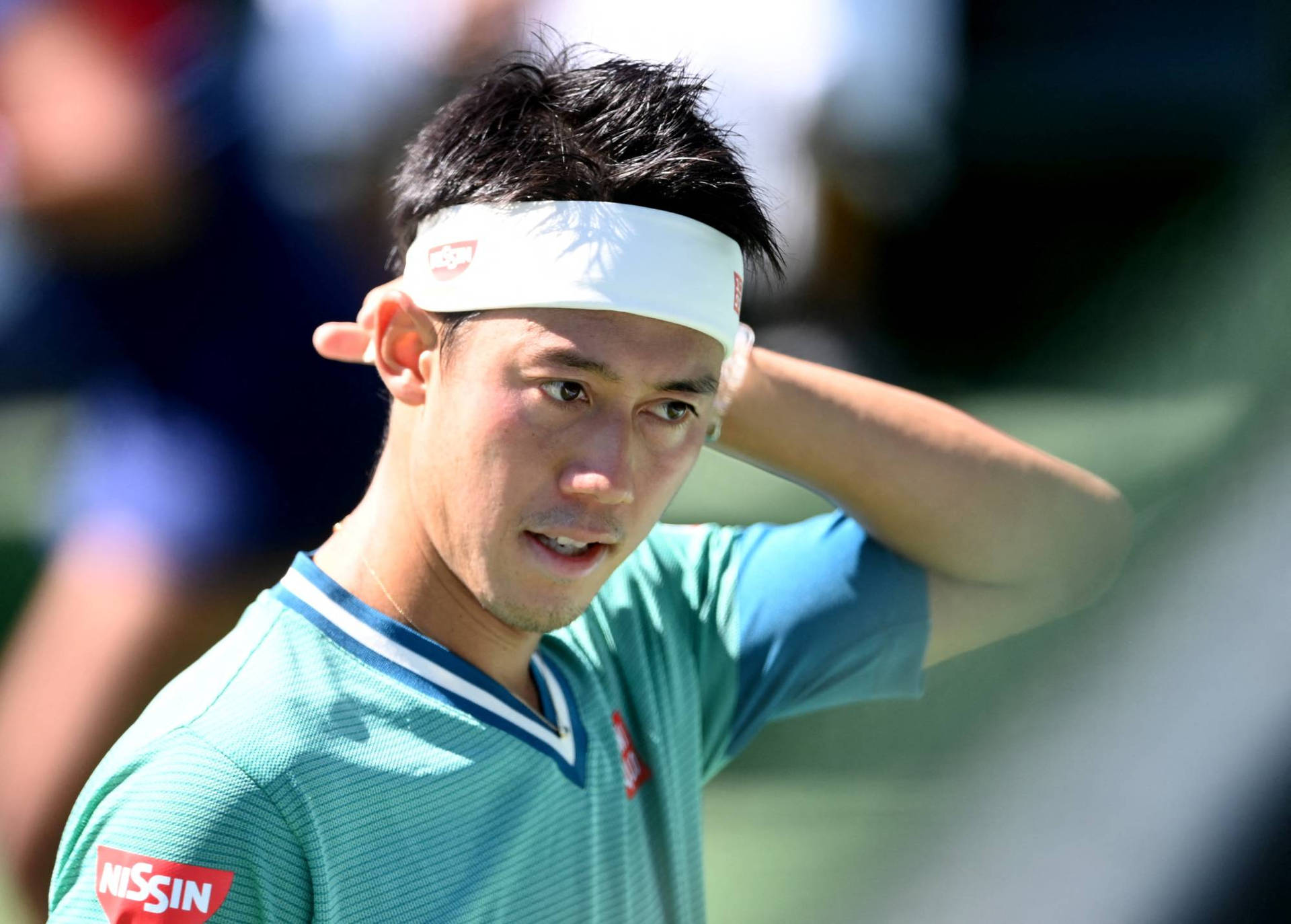 Kei Nishikori Pondering Strategy On The Tennis Court Background