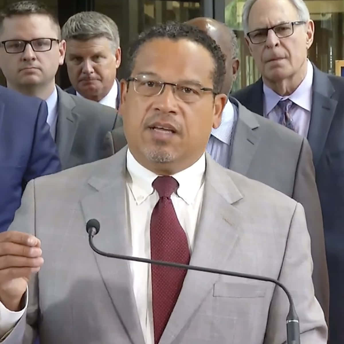 Keith Ellison With Men Behind Him Background
