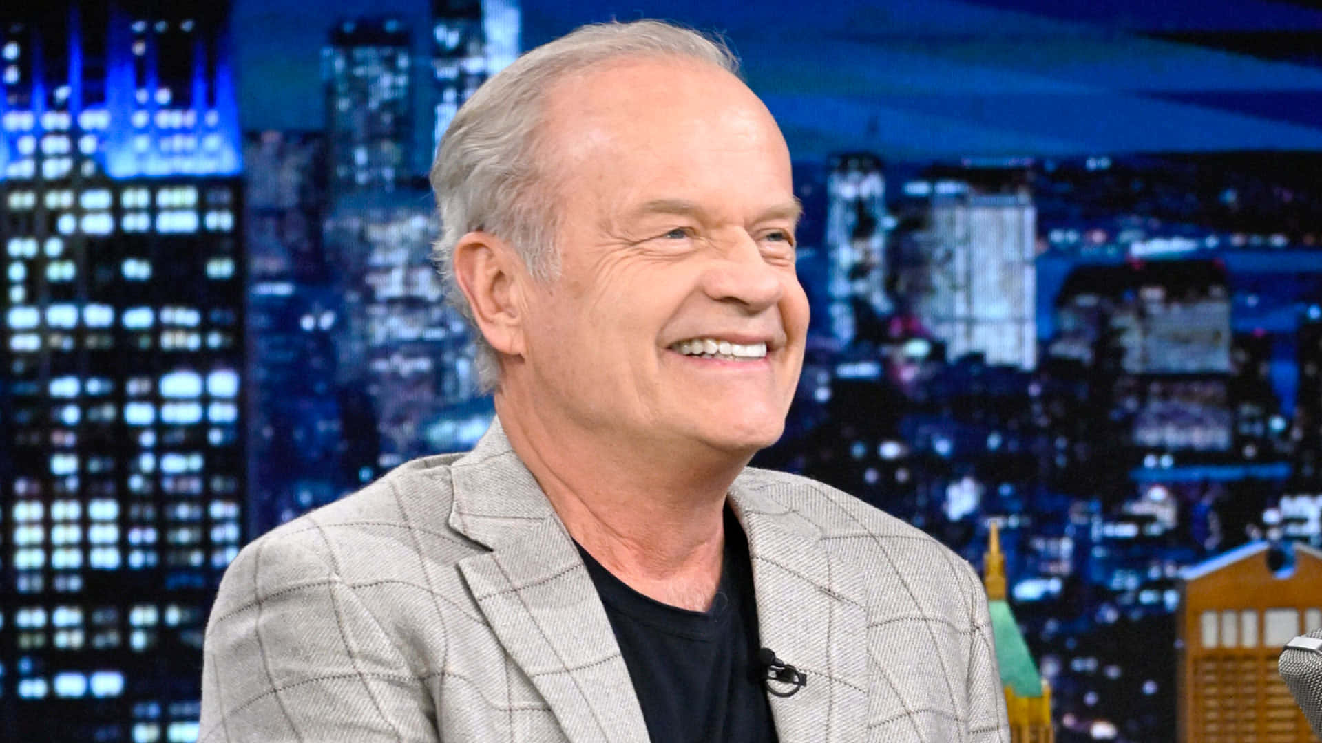 Kelsey Grammer Striking A Pose In A Suit Background