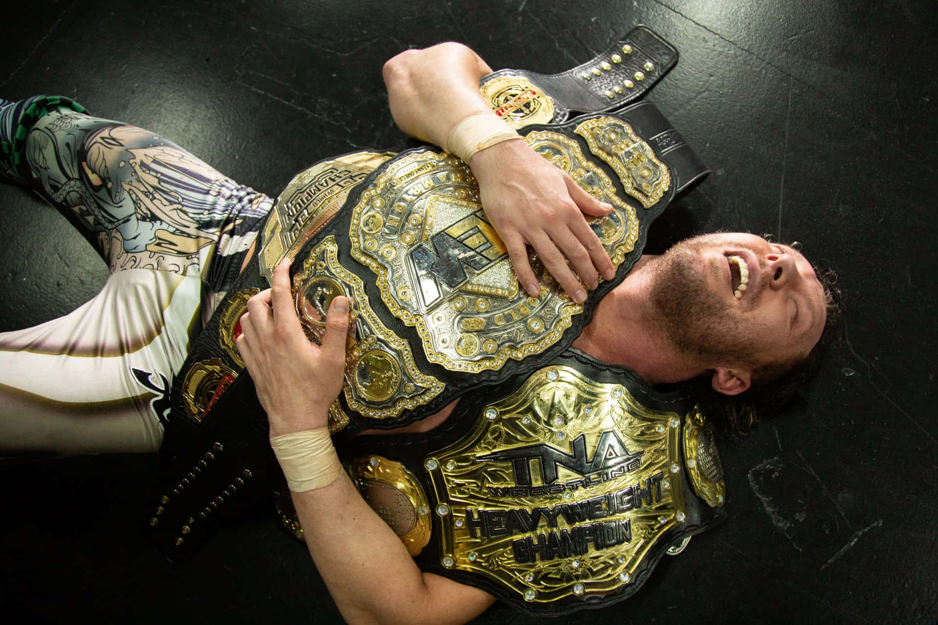 Kenny Omega Hugging His Championship Belts