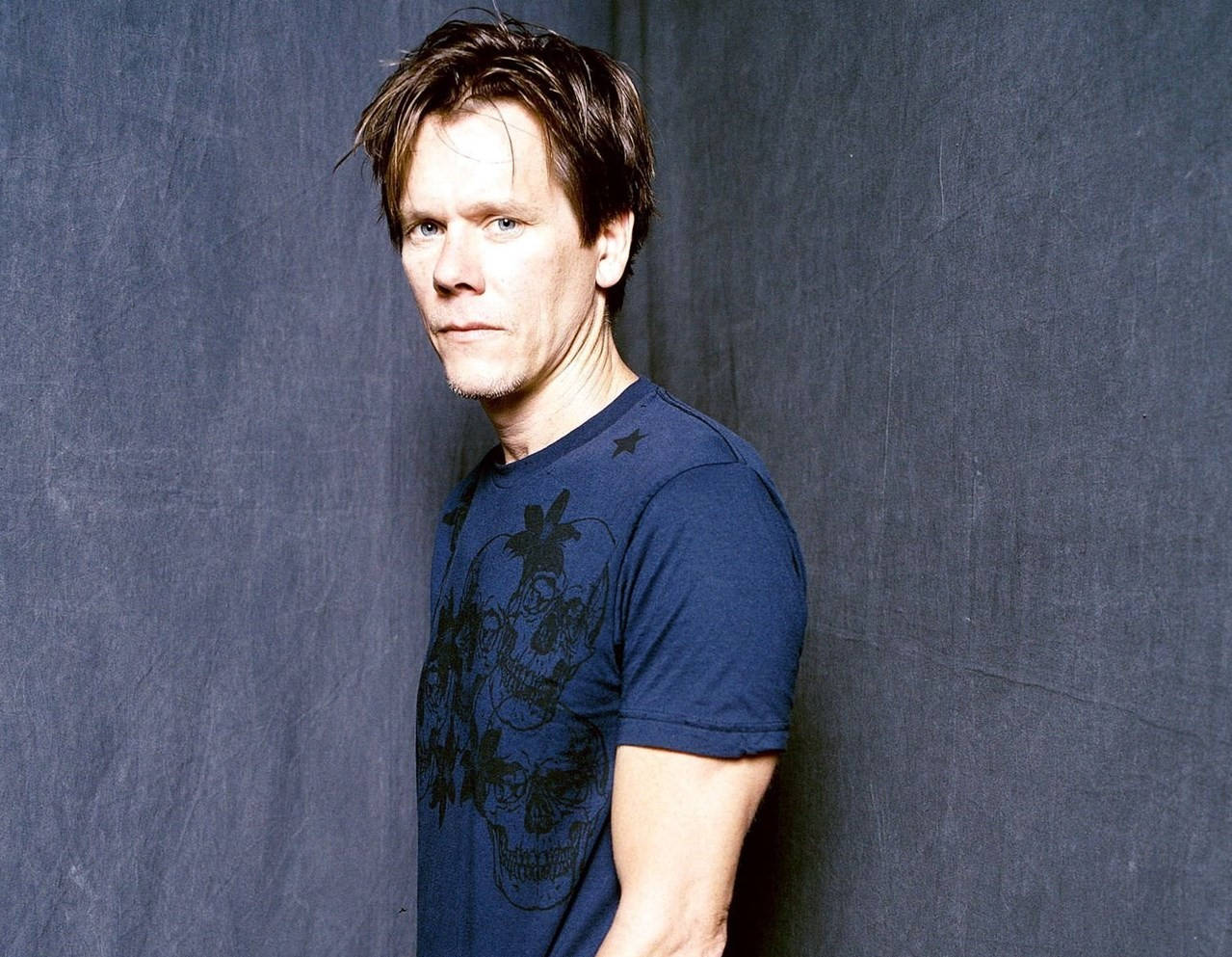 Kevin Bacon In Gray Wall Background