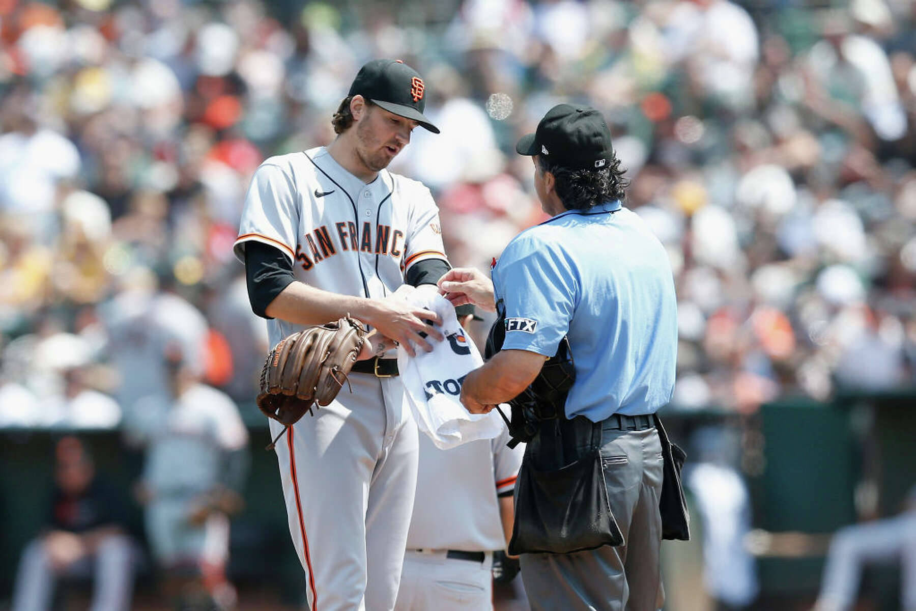 Kevin Gausman Covering White Towel On His Left Arm Background