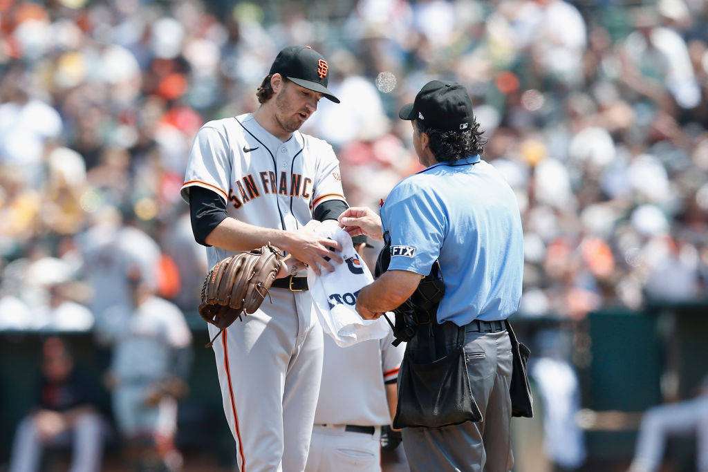 Kevin Gausman Covering White Towel On His Left Arm Background