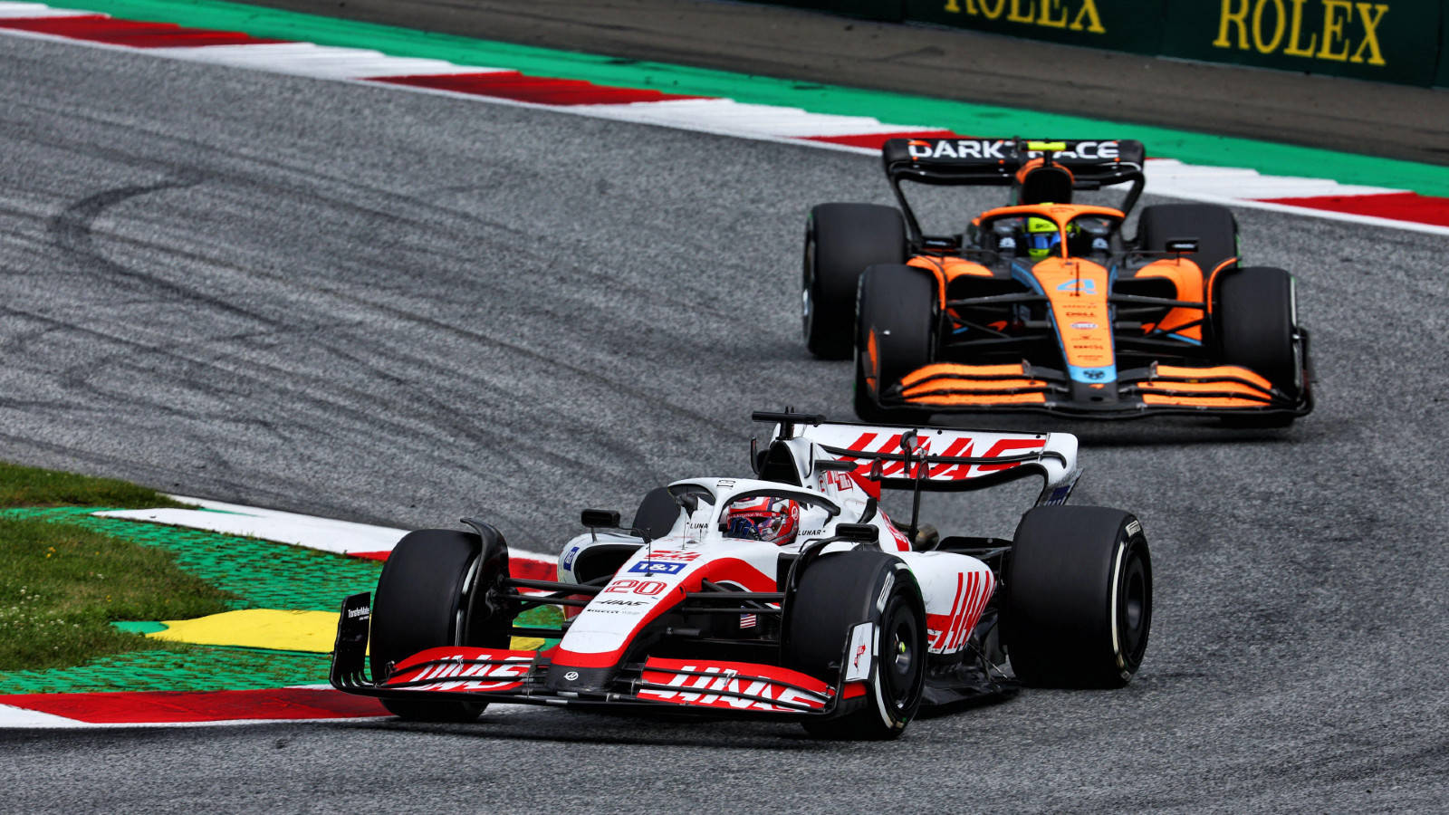 Kevin Magnussen In Intense Race With Mclaren Background