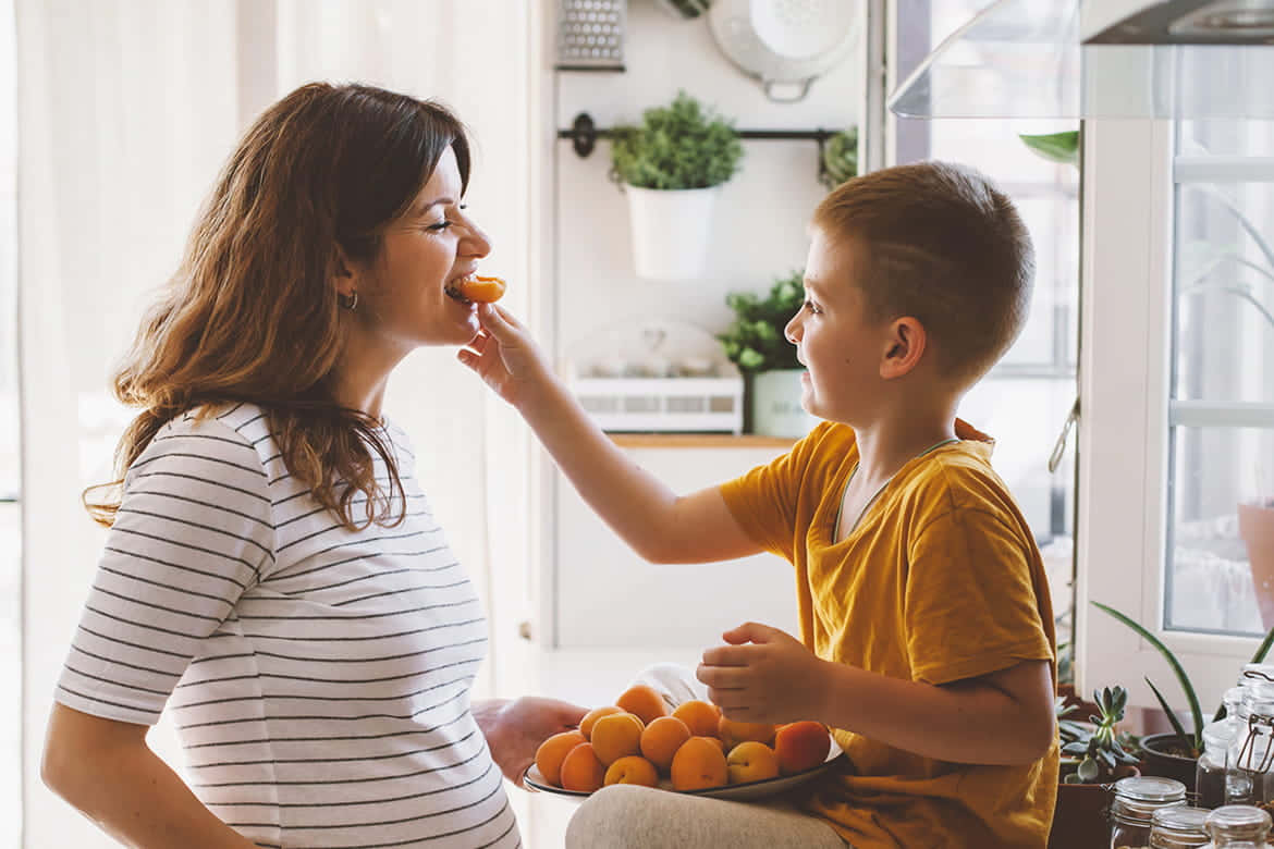 Kid Feeding Nauseous Pregnant Woman