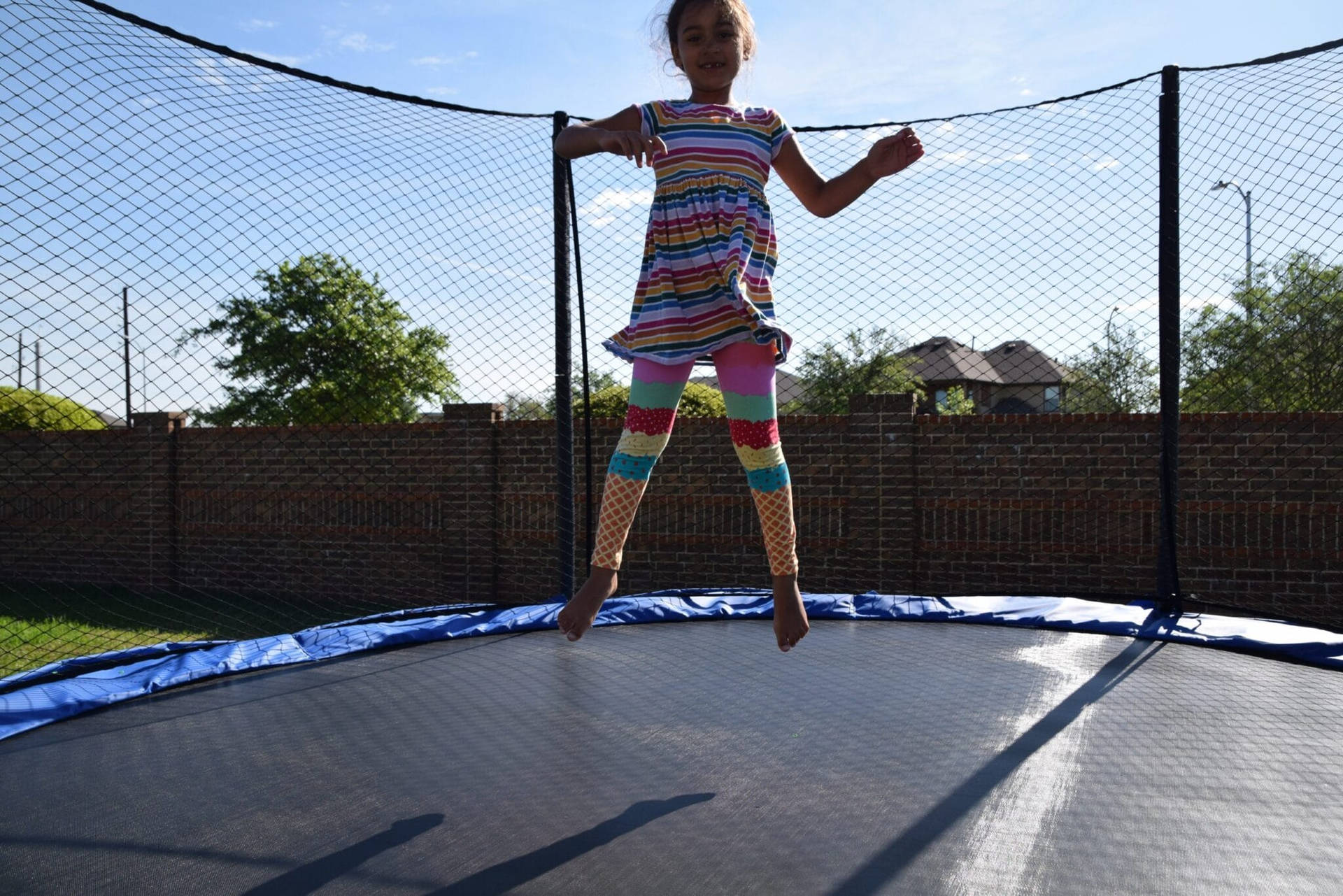 Kid Jumping On A Trampoline Background