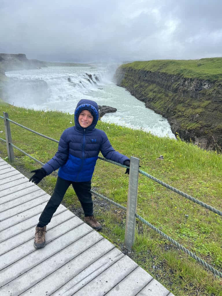 Kid Visiting In Gullfoss Waterfall In Southwest Iceland Background