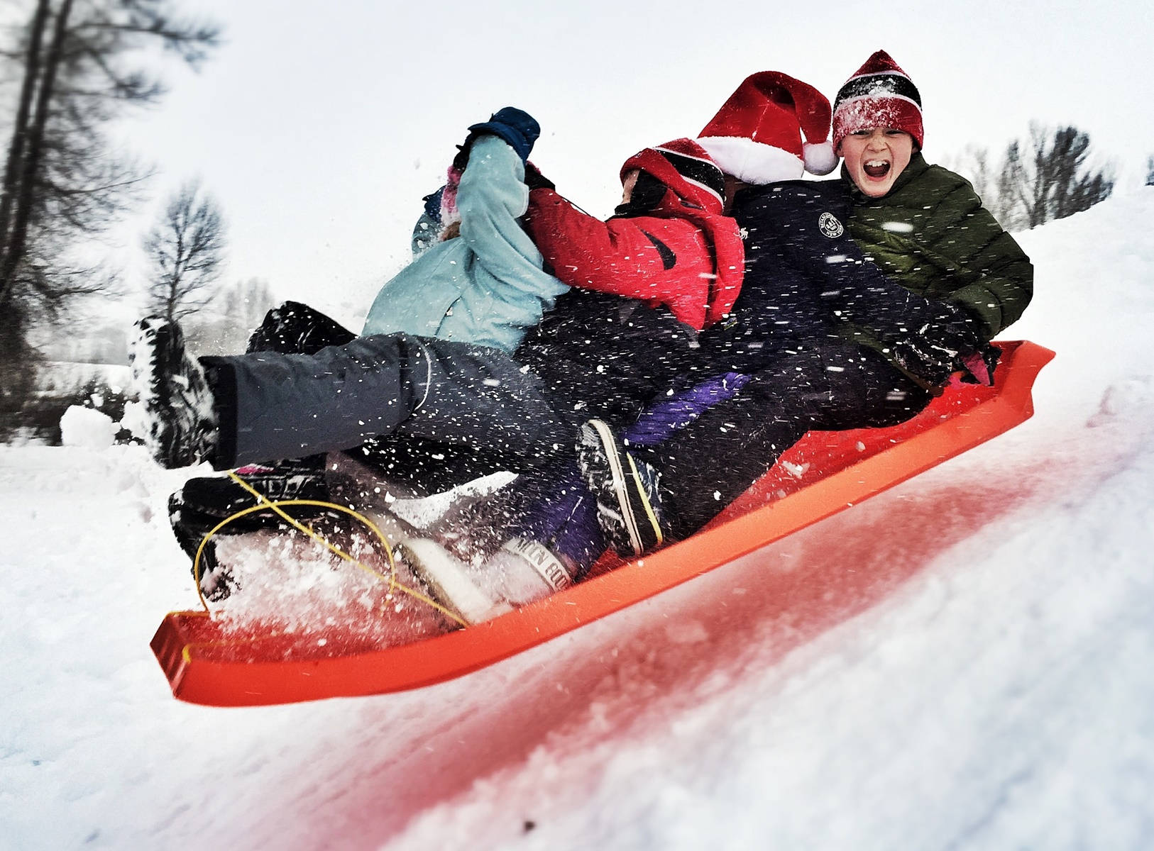 Kids Enjoy Sledding Down The Hill. Background