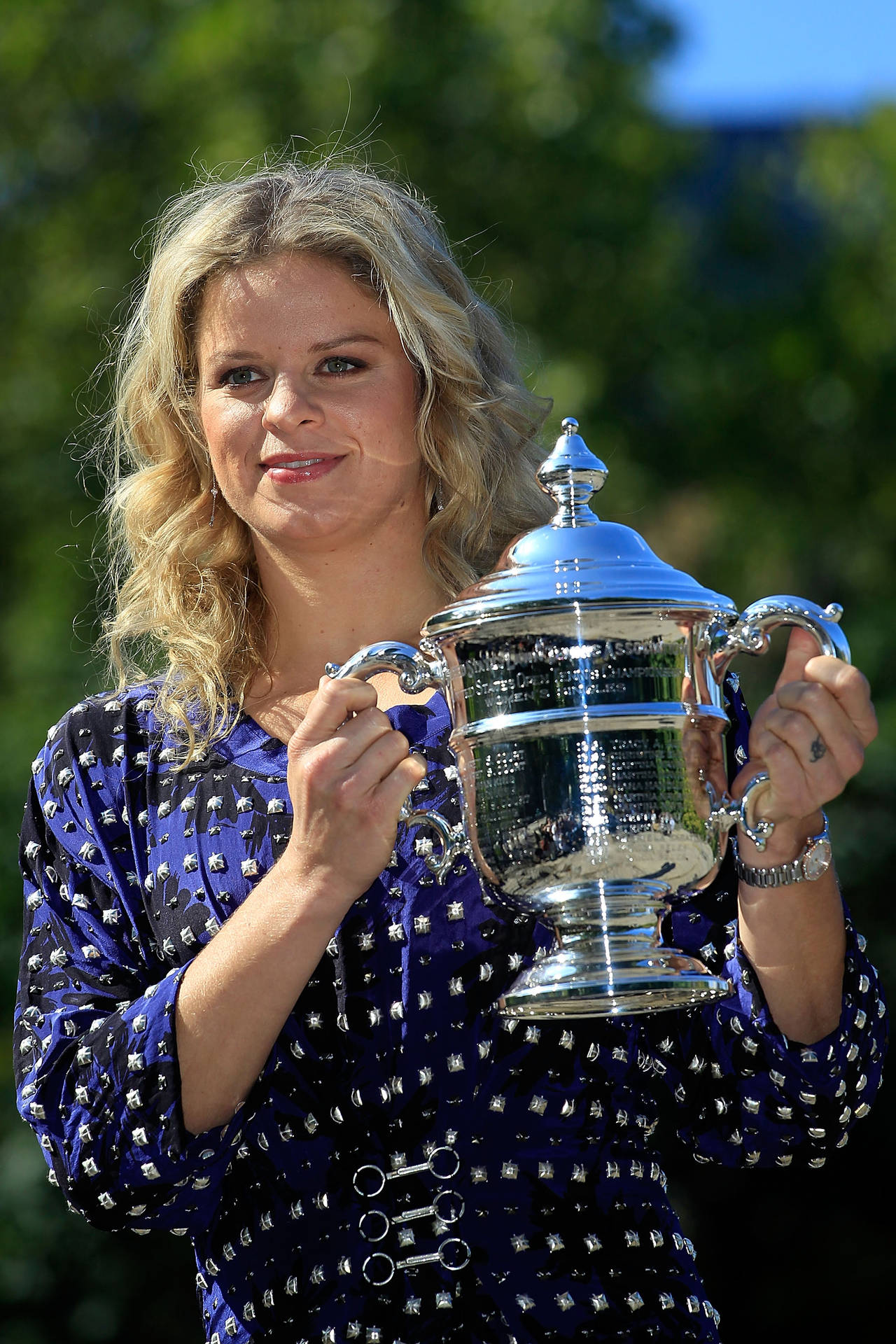 Kim Clijsters Triumphantly Holding Silver Trophy Background