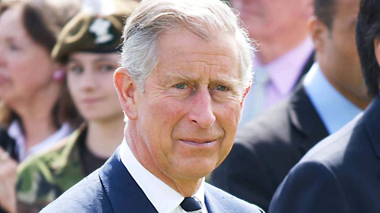 King Charles Iii Smirking At Camera Background