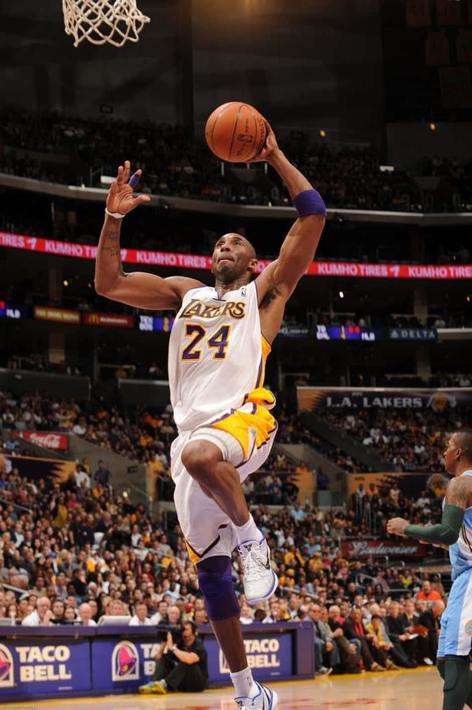 Kobe Bryant Captures The Crowd As He Reaches For The Rim Background