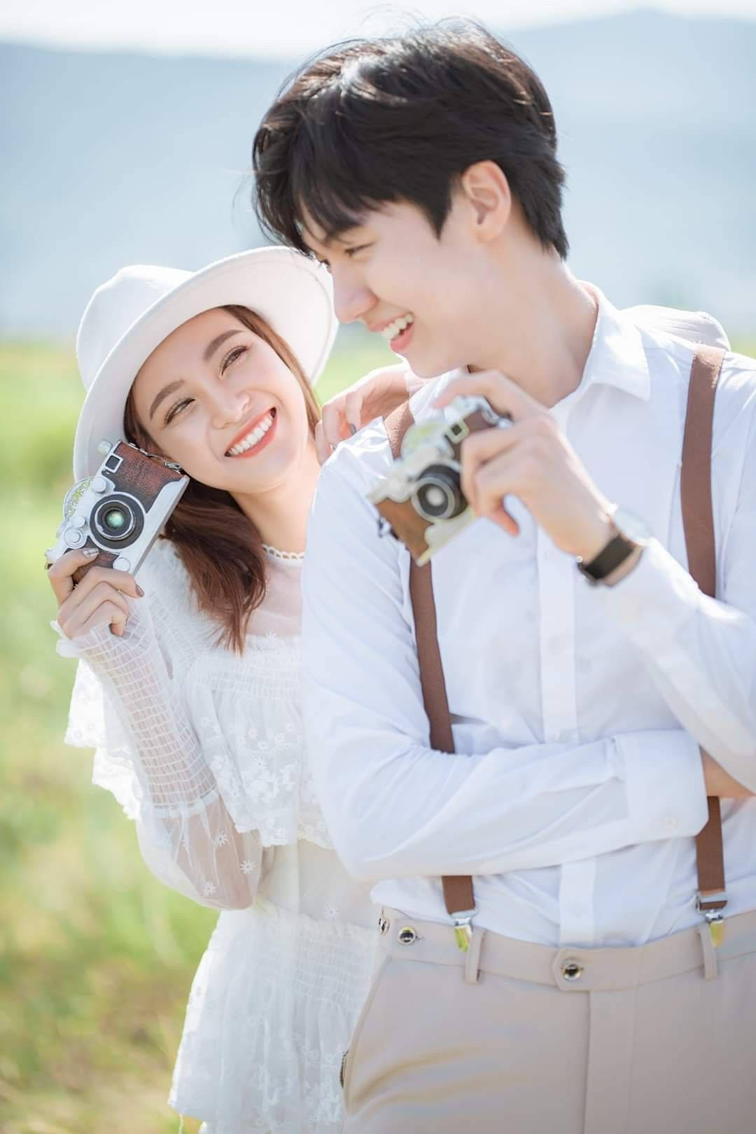 Korean Couple Holding Cameras Background